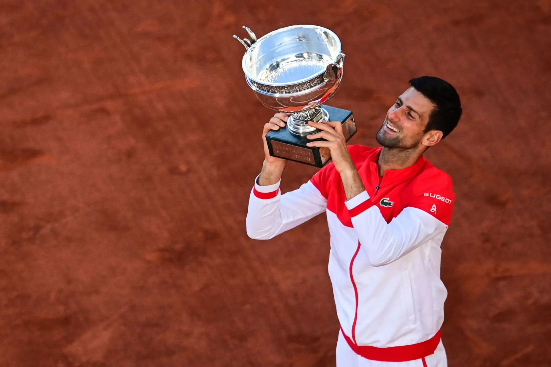 El serbio Novak Djokovic posa con la Copa Mousquetaires (Los Mosqueteros) después de vencer al griego Stefanos Tsitsipas al final de su último partido de tenis masculino el día 15 del torneo de tenis Roland Garros 2021 del Abierto de Francia en París.
Foto: AFP