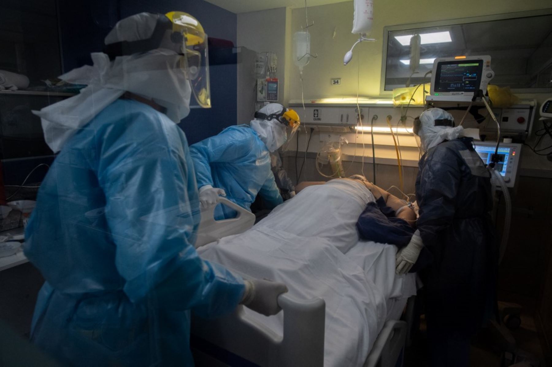 Trabajadores de la salud atienden a un paciente en una Unidad de Cuidados Intensivos (UCI) Covid-19, en un hospital privado de Montevideo. Foto: AFP