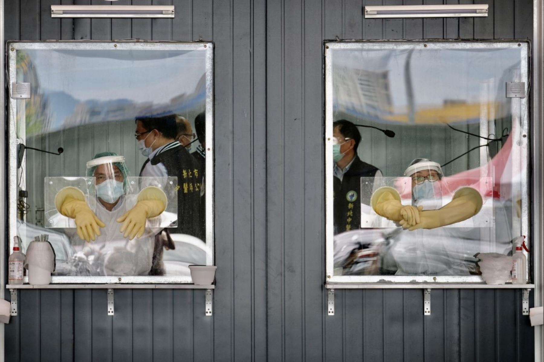 Se ve al personal médico detrás de sus áreas de trabajo selladas en un área de detección de prueba de hisopo para el coronavirus Covid-19 en la ciudad de Nueva Taipei. Foto: AFP
