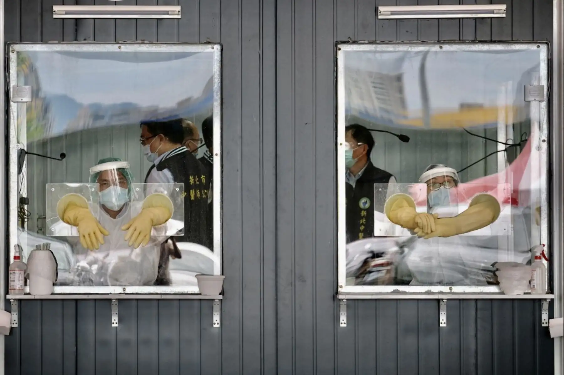 Se ve al personal médico detrás de sus áreas de trabajo selladas en un área de detección de prueba de hisopo para el coronavirus Covid-19 en la ciudad de Nueva Taipei. Foto: AFP