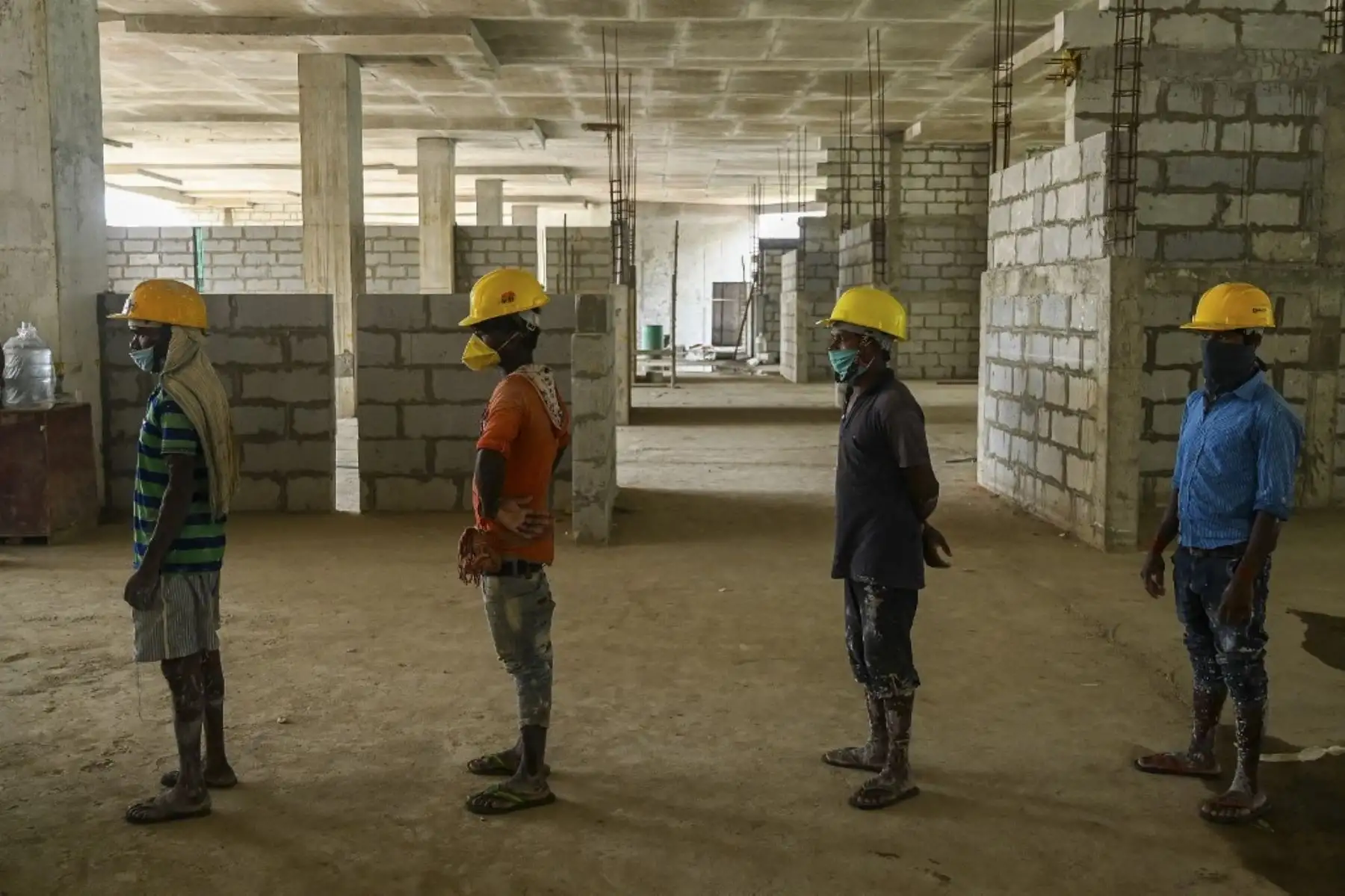 Los trabajadores esperan en la cola su turno para someterse a una prueba de reacción en cadena de la polimerasa con transcripción inversa (RT-PCR) para el coronavirus Covid-19 en un sitio de construcción en Nueva Delhi. Foto: AFP