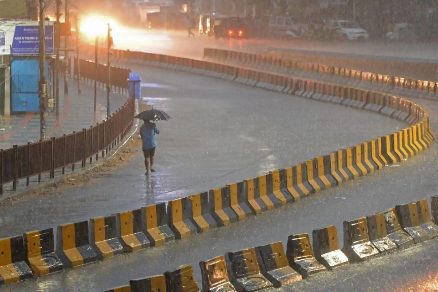 Un hombre camina bajo la lluvia por una carretera desierta durante un bloqueo impuesto por el gobierno para frenar la propagación del coronavirus Covid-19 en Secunderabad. Foto: AFP
