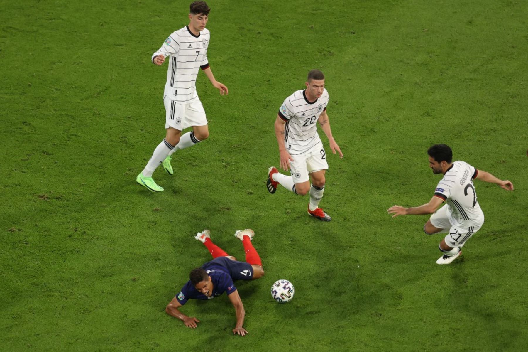 El defensa francés Raphael Varane (abajo) cae como (arriba LR) el delantero alemán Kai Havertz, el defensor alemán Robin Gosens y el mediocampista alemán Ilkay Gundogan durante el partido de fútbol del Grupo F de la UEFA EURO 2020 entre Francia y Alemania en el Allianz Arena en Múnich. Foto: AFP