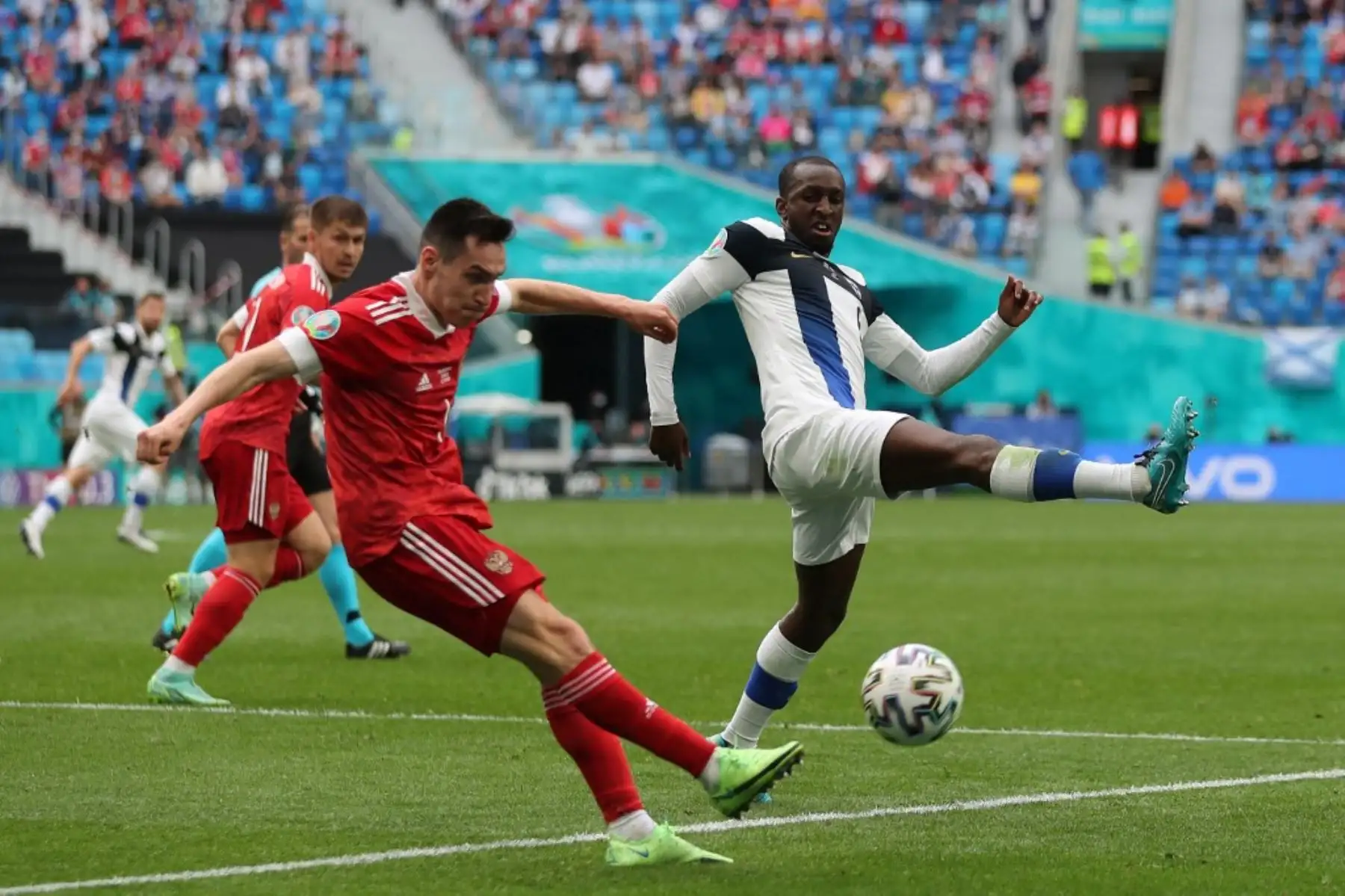 El mediocampista ruso Magomed Ozdoev (izq.) Dispara al mediocampista finlandés Glen Kamara durante el partido de fútbol del Grupo B de la UEFA EURO 2020 entre Finlandia y Rusia en el estadio de San Petersburgo en San Petersburgo el 16 de junio de 2021. Foto: AFP