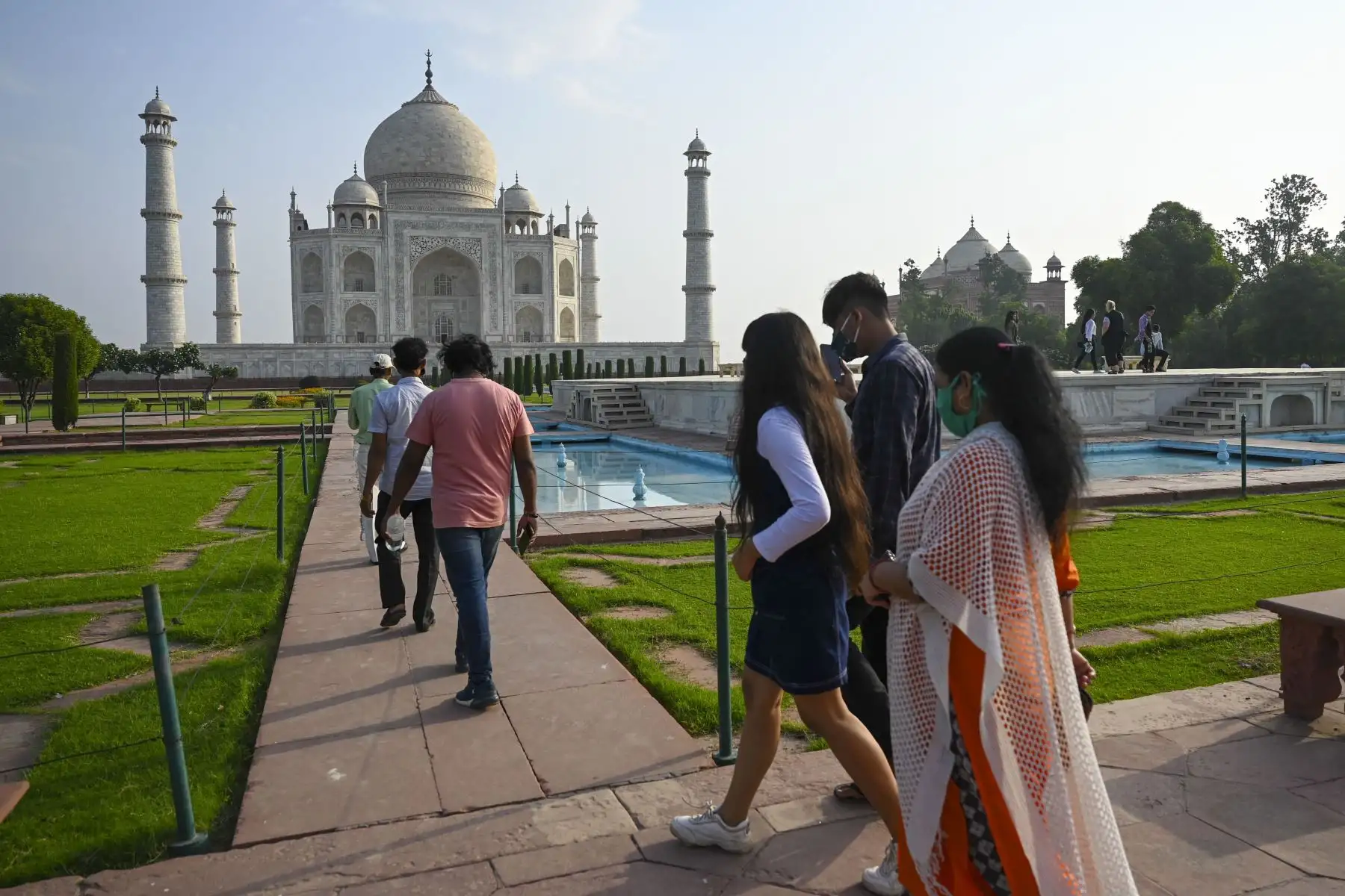 Los turistas visitan el Taj Mahal después de que se reabrió a los visitantes luego de que las autoridades suavizaran las restricciones del coronavirus en Agra.
Foto: AFP