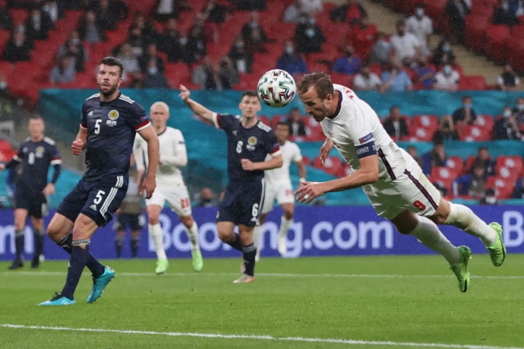 El delantero de Inglaterra Harry Kane (R) cabecea el balón durante el partido de fútbol del Grupo D de la UEFA EURO 2020 entre Inglaterra y Escocia en el estadio de Wembley en Londres el 18 de junio de 2021. Foto: AFP