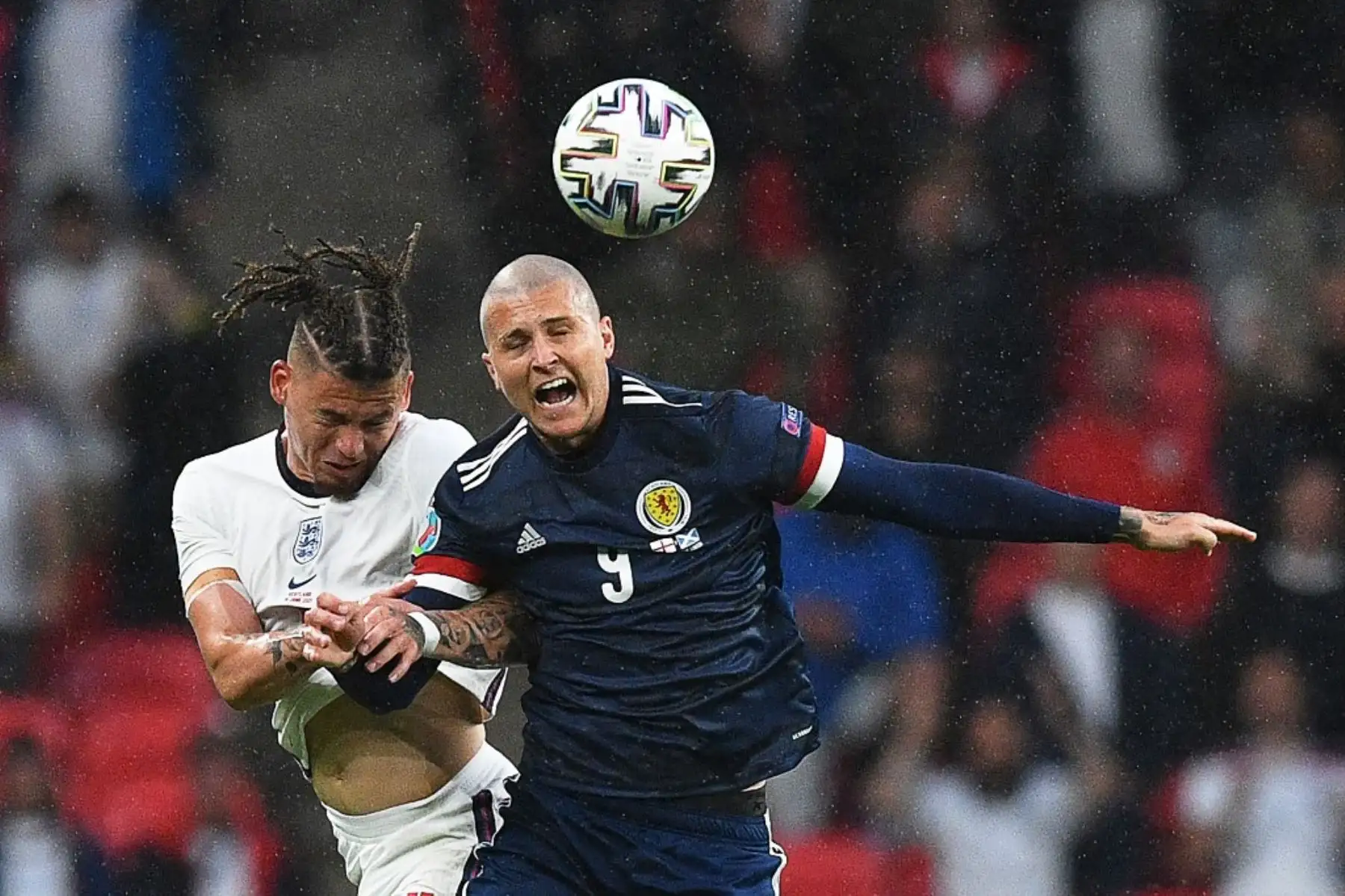 El mediocampista de Inglaterra, Kalvin Phillips, y el delantero de Escocia, Lyndon Dykes, compiten por el balón durante el partido de fútbol del Grupo D de la UEFA EURO 2020 entre Inglaterra y Escocia en el estadio de Wembley en Londres el 18 de junio de 2021. Foto: AFP