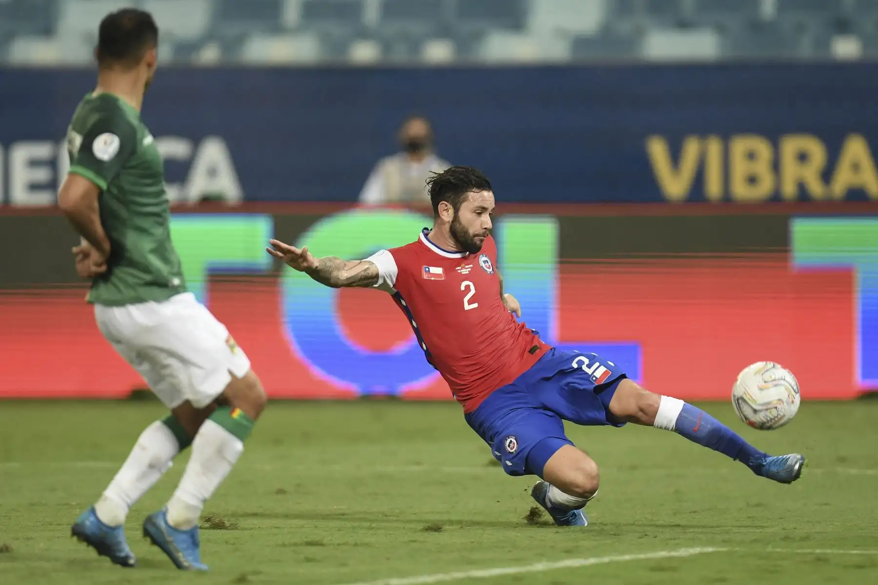 El chileno Eugenio Mena dispara el balón mientras el boliviano Diego Bejarano intenta bloquearlo durante partido de la fase de grupos de la Copa América, en el Pantanal Arena de Cuiabá, Brasil. Foto. AFP