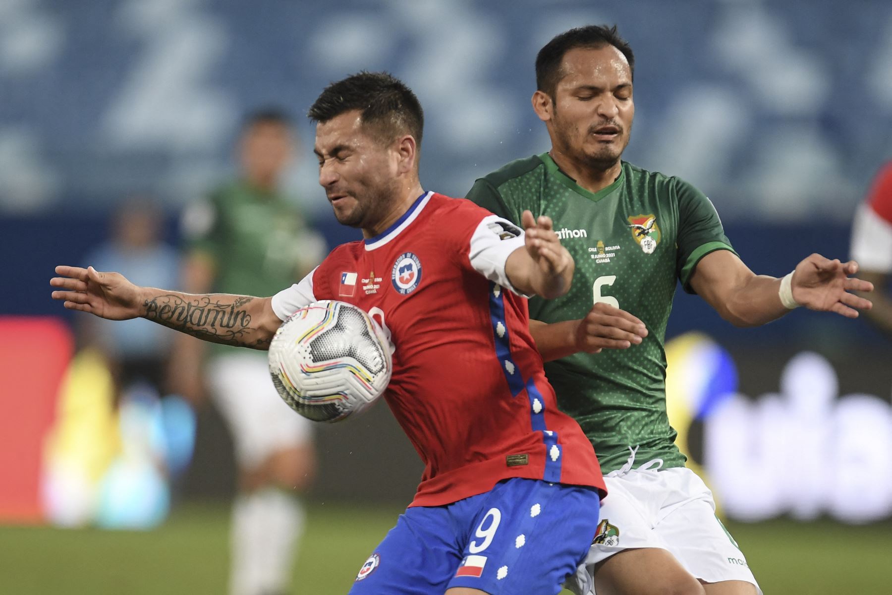 El chileno Jean Meneses y el boliviano Leonel Justiniano compiten por el balón durante el partido por la fase de grupos de la Copa América, en el Pantanal Arena de Cuiabá, Brasil. Foto: AFP