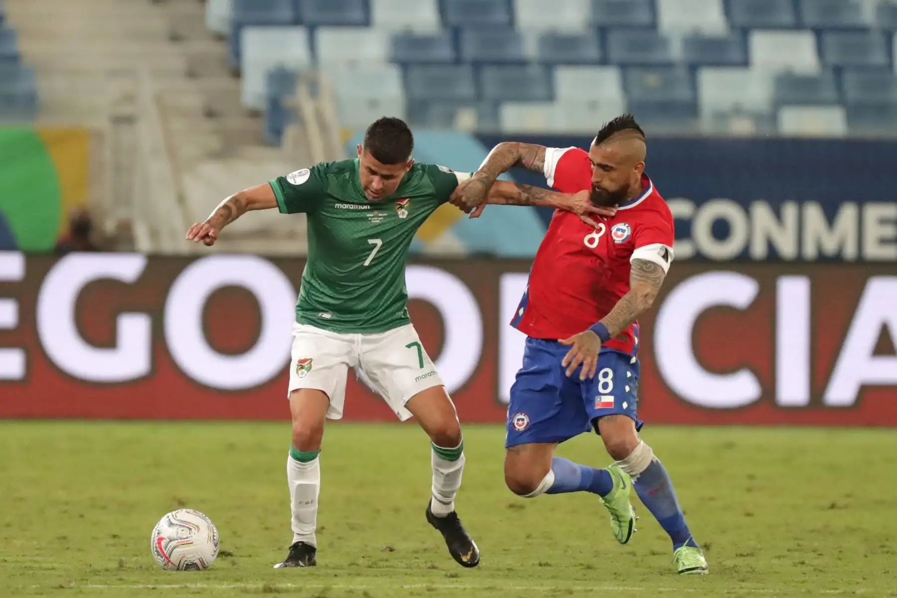 Arturo Vidal de Chile disputa el balón con Juan Carlos Arce de Bolivia durante un partido por el grupo A de la Copa América, en el estadio Arena Pantanal de Cuiabá, Brasil. Foto: EFE