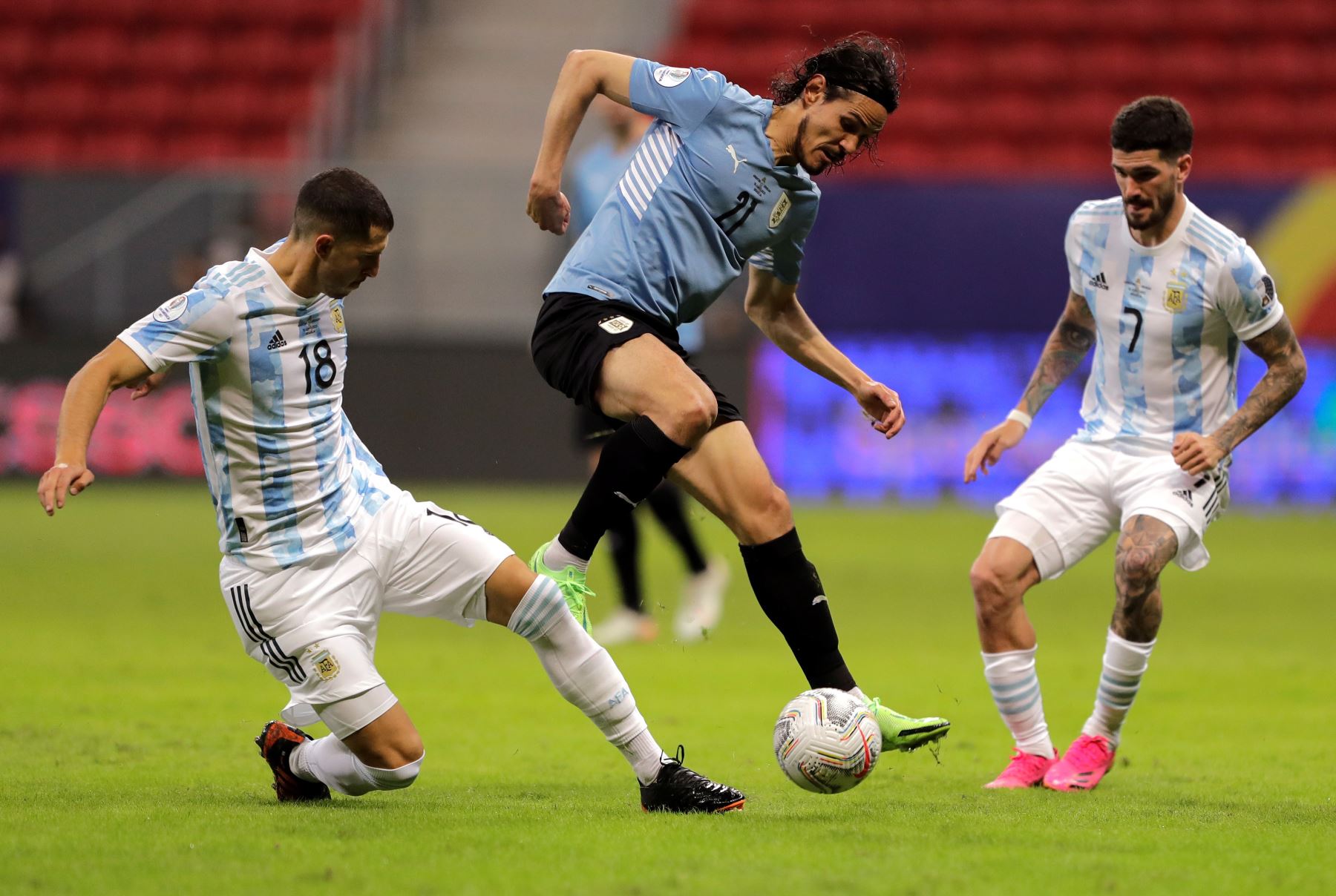 Guido Rodríguez y Rodrigo de Paul de Argentina disputan el balón con Edinson Cavani de Uruguay durante un partido por el grupo A de la Copa América en el estadio Mané Garrincha, en Brasil. Foto: EFE