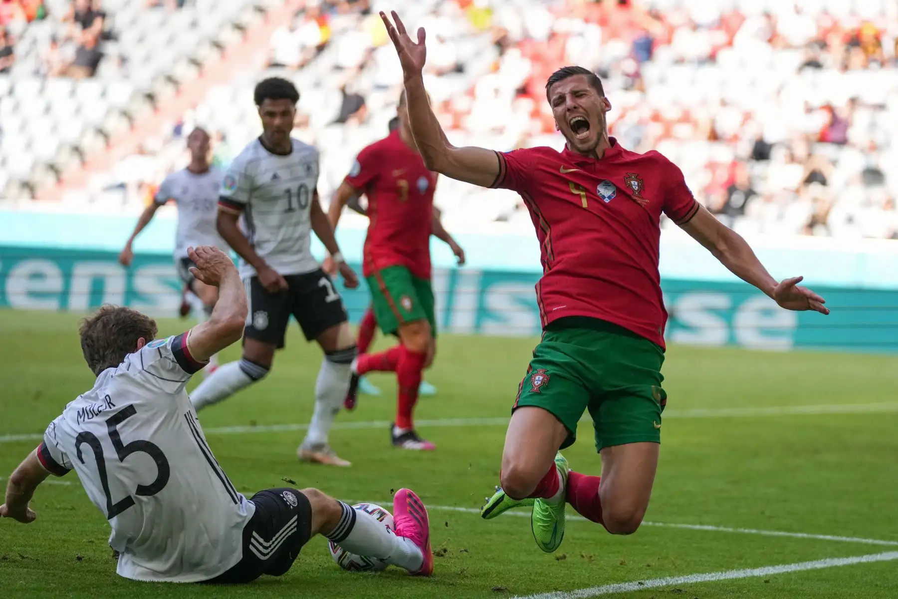 El defensor de Portugal Ruben Dias  cae en un desafío con el delantero alemán Thomas Mueller durante el partido de fútbol del Grupo F de la UEFA EURO 2020 entre Portugal y Alemania en el Allianz Arena de Múnich.
Foto: AFP