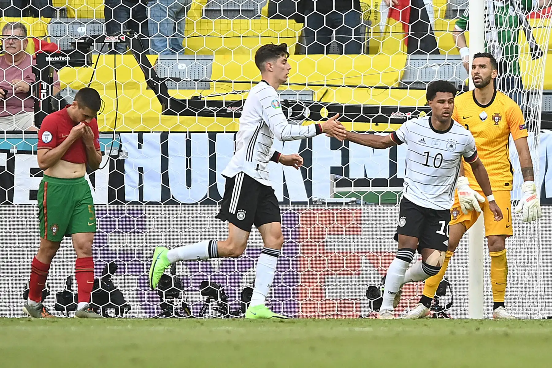 El centrocampista alemán Serge Gnabry celebra su segundo gol, un gol en propia meta anotado por el defensor de Portugal Raphael Guerreiro con el delantero alemán Kai Havertz  durante el partido de fútbol del Grupo F de la UEFA EURO 2020 entre Portugal y Alemania en el Allianz Arena en Munich.
Foto: AFP