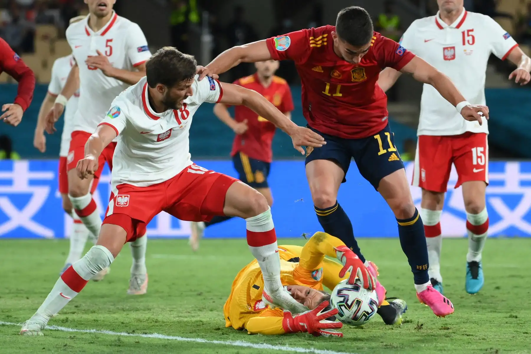 El portero polaco Wojciech Szczesny (C) intenta agarrar el balón mientras el defensor polaco Bartosz Bereszynski (L) desafía al mediocampista español Ferran Torres (R) durante el partido de fútbol del Grupo E de la UEFA EURO 2020 entre España y Polonia en el Estadio La Cartuja en Sevilla, España. Foto: AFP