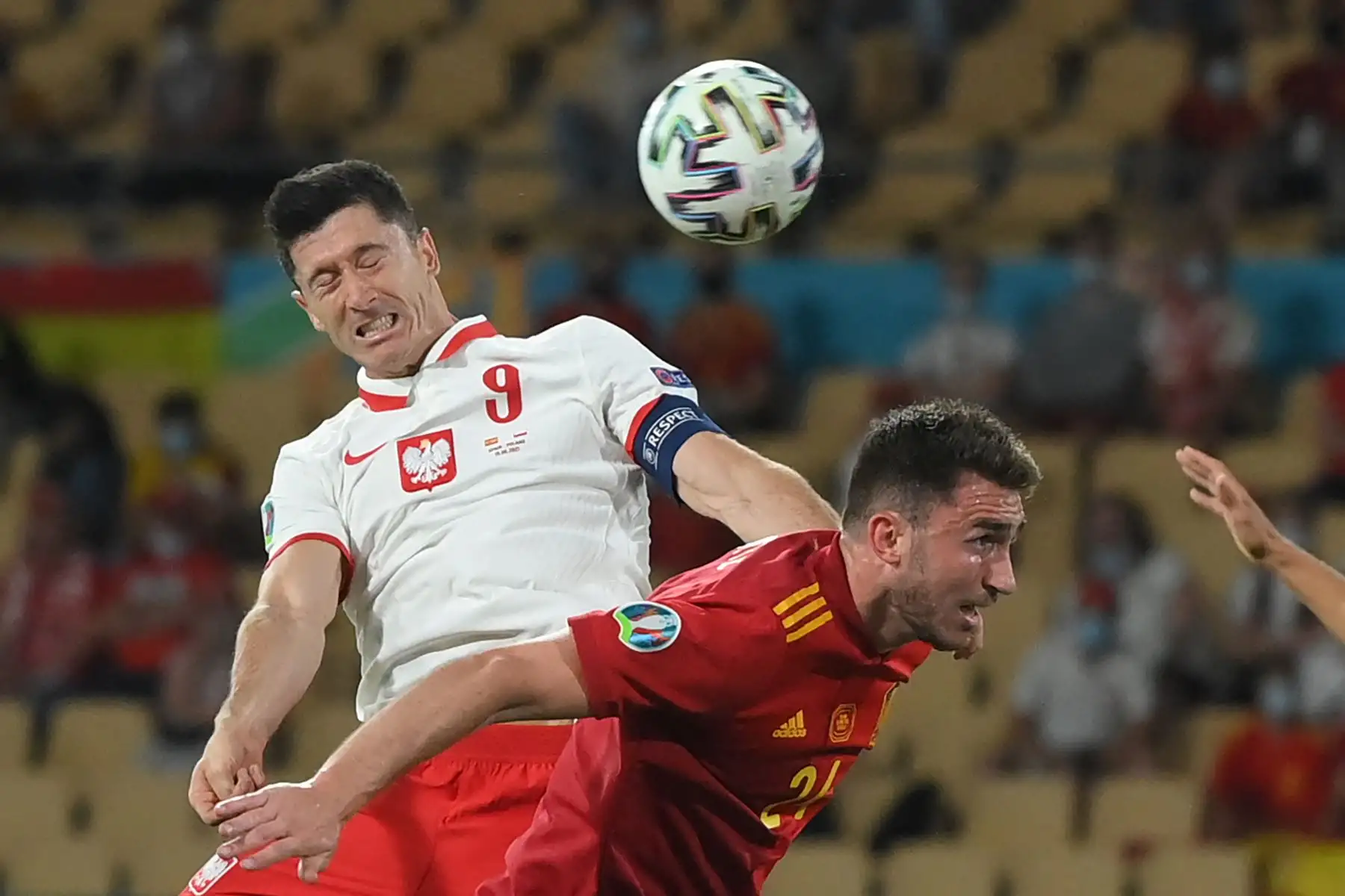 El delantero polaco Robert Lewandowski (L) cabecea el balón sobre el defensor español Aymeric Laporte para marcar el empate durante el partido de fútbol del Grupo E de la UEFA EURO 2020 entre España y Polonia en el Estadio La Cartuja en Sevilla, España. Foto: AFP
