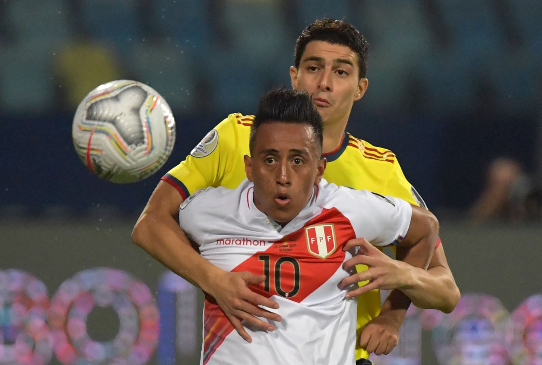 El peruano Christian Cueva (delantero) y el colombiano John Medina compiten por el balón durante el partido de la fase de grupos del torneo de fútbol Conmebol Copa América 2021 en el Estadio Olímpico de Goiania, Brasil. Foto: AFP