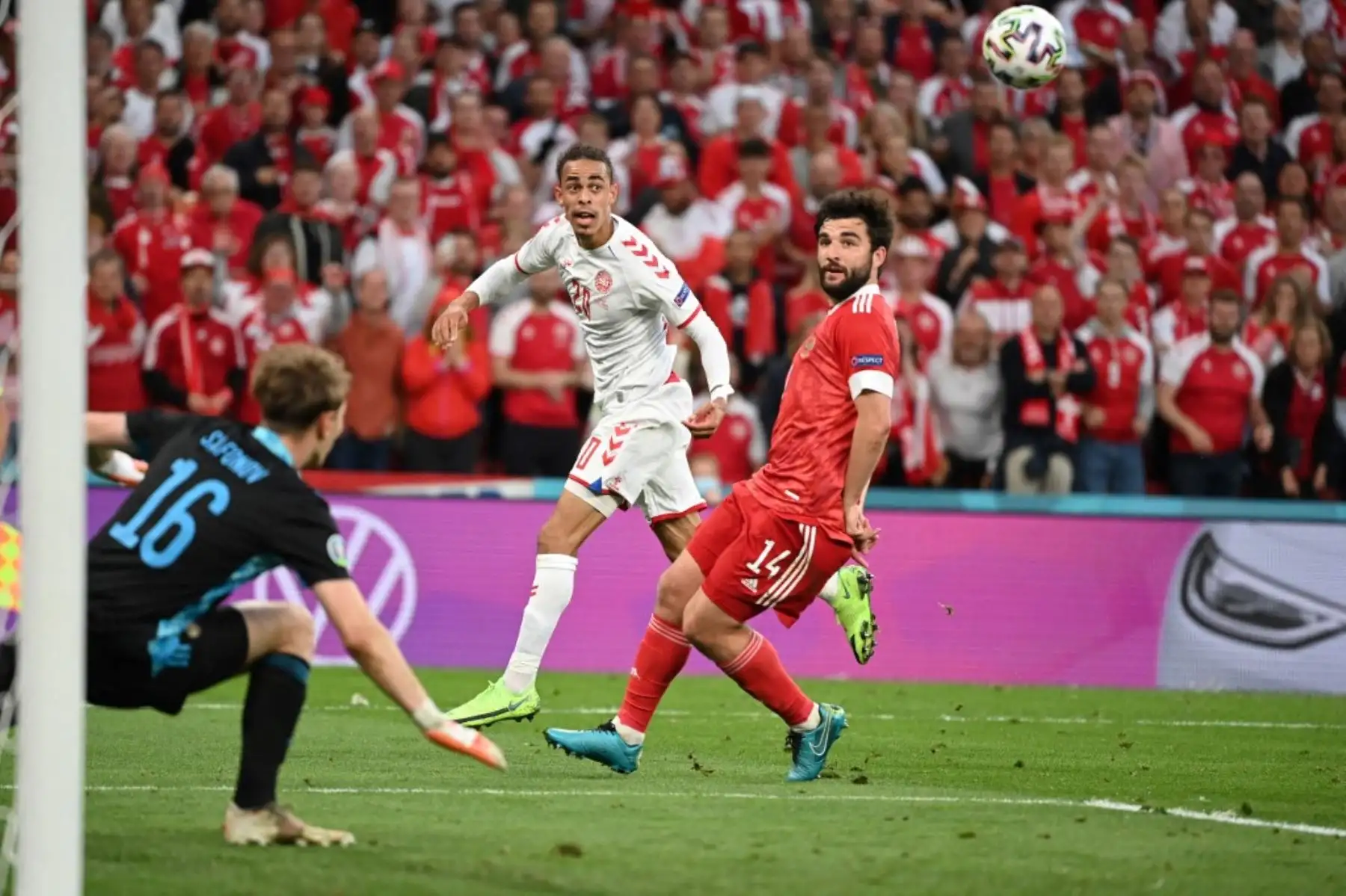 El delantero de Dinamarca Yussuf Poulsen (C) y el defensor de Rusia Georgiy Dzhikiya (R) miran el balón durante el partido de fútbol del Grupo B de la UEFA EURO 2020 entre Rusia y Dinamarca en el estadio Parken de Copenhague el 21 de junio de 2021. Foto: AFP