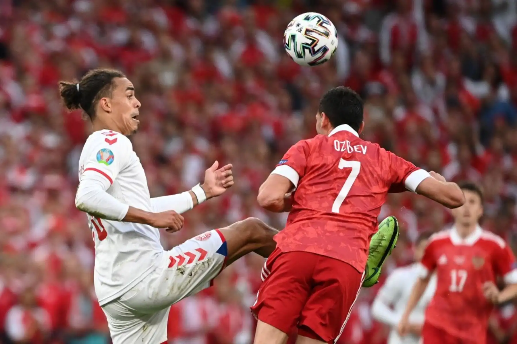 El delantero de Dinamarca Yussuf Poulsen (L) lucha por el balón con el centrocampista ruso Magomed Ozdoev durante el partido de fútbol del Grupo B de la UEFA EURO 2020 entre Rusia y Dinamarca en el estadio Parken de Copenhague el 21 de junio de 2021. Foto: AFP