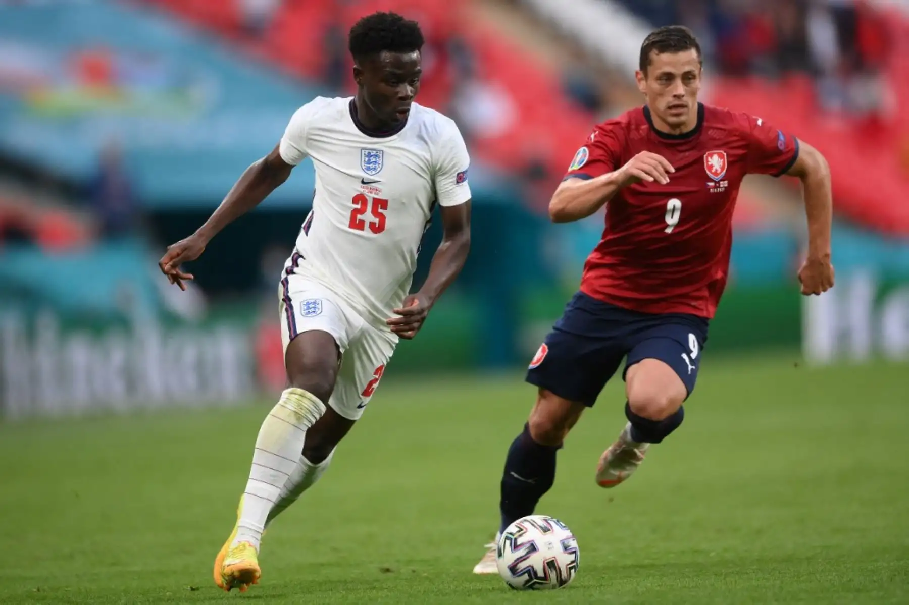 El centrocampista de Inglaterra Bukayo Saka (L) y el centrocampista de la República Checa Tomas Holes compiten por el balón durante el partido de fútbol del Grupo D de la UEFA EURO 2020 entre la República Checa e Inglaterra en el estadio de Wembley en Londres el 22 de junio de 2021. Foto: AFP