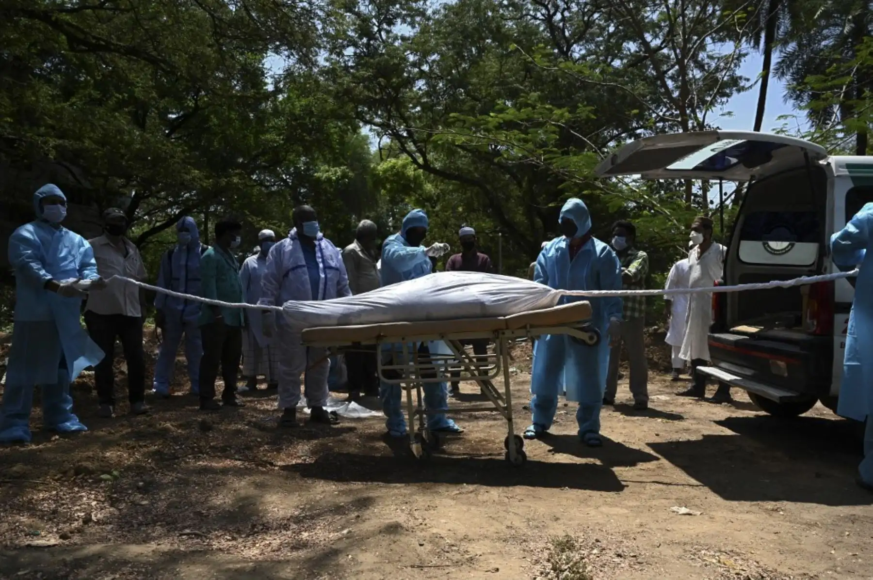 Voluntarios con equipo de protección se preparan para enterrar el cuerpo de una víctima del coronavirus Covid-19 en un cementerio en Chennai. Foto: AFP