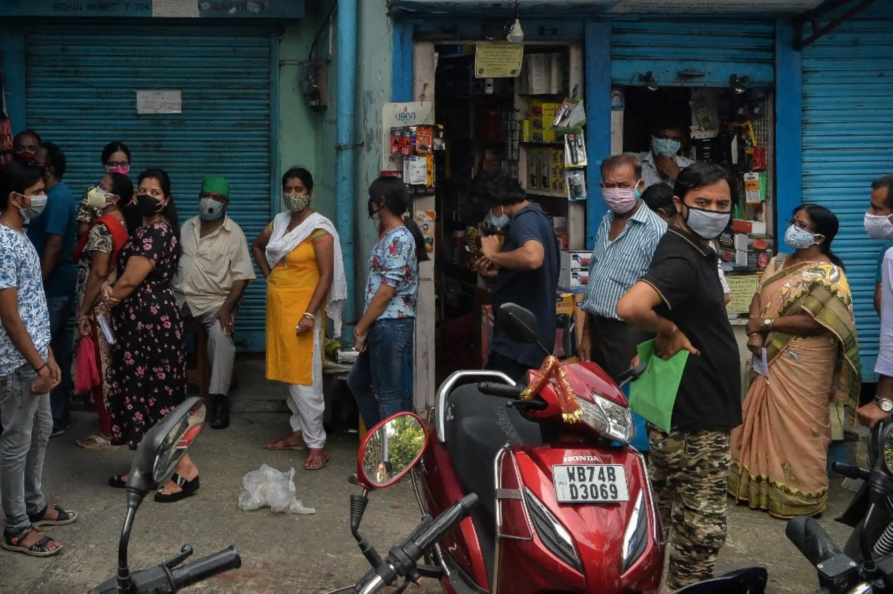 La gente hace cola para vacunarse con la vacuna contra el coronavirus Covid-19 fuera de un campamento establecido en la oficina de una asociación de mercado en Siliguri. Foto: AFP