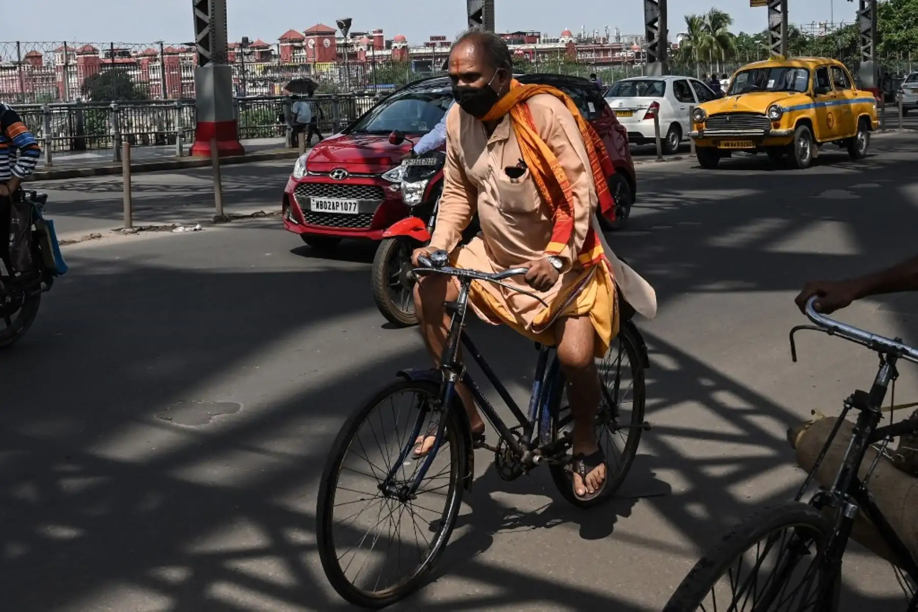 Un hombre cruza el puente Howrah en su bicicleta mientras el gobierno estatal suspendió el transporte público regular durante un bloqueo impuesto para frenar la propagación del coronavirus Covid-19, en Calcuta el 23 de junio de 2021. Foto: AFP