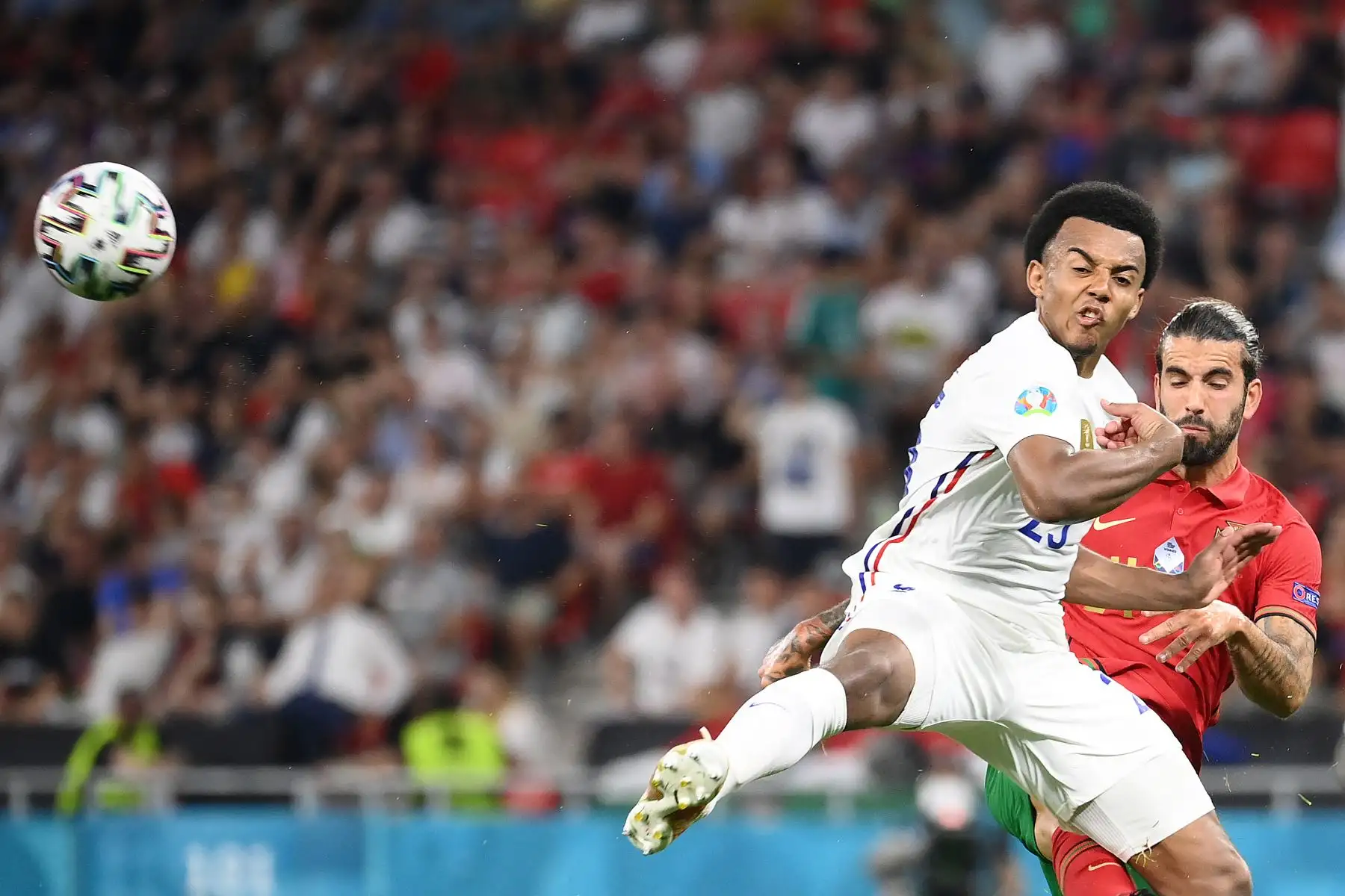El defensa francés Jules Kounde y el mediocampista portugués Sergio Oliveira compiten por el balón durante el partido por el Grupo F de la UEFA EURO 2020. Foto: AFP