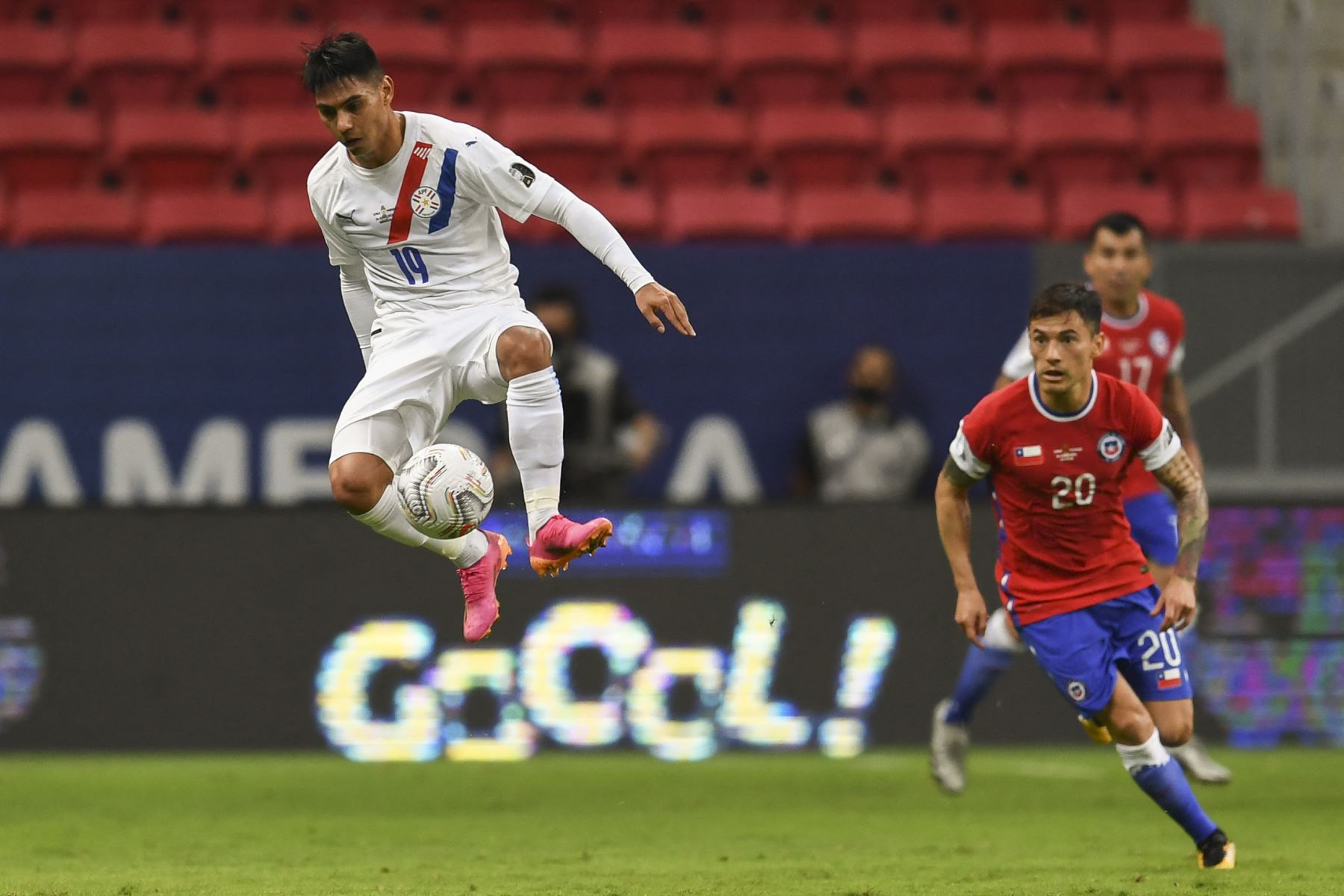 Santiago Arzamendia de Paraguay salta por el balón ante la marca del chileno Charles Aranguiz durante el partido de la fase de grupos de la América 2021, en el Estadio Mane Garrincha de Brasilia. Foto: AFP