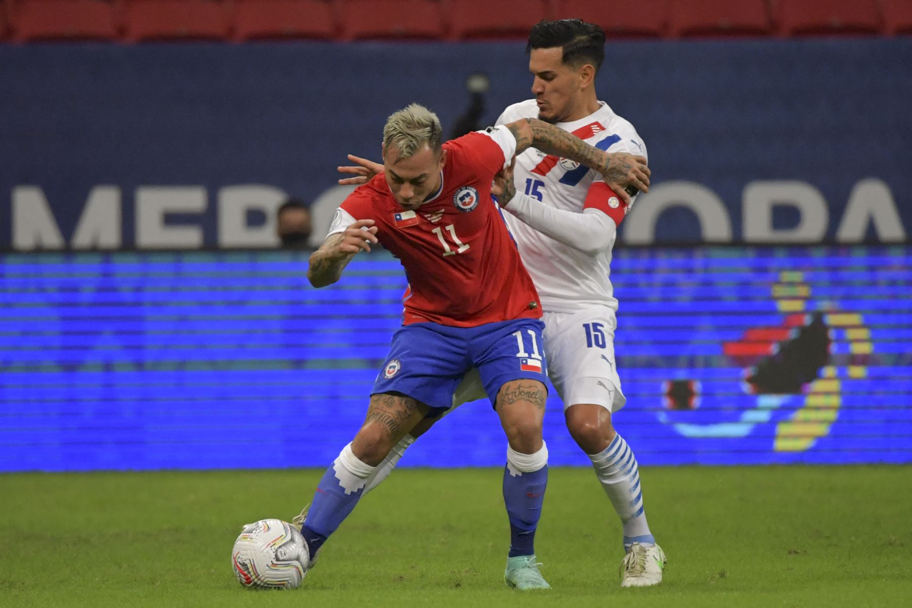 El chileno Eduardo Vargas y el paraguayo Gustavo Gómez compiten por el balón durante el partido de la fase de grupos de la Copa América 2021, en el estadio Mane Garrincha de Brasilia. Foto: AFP