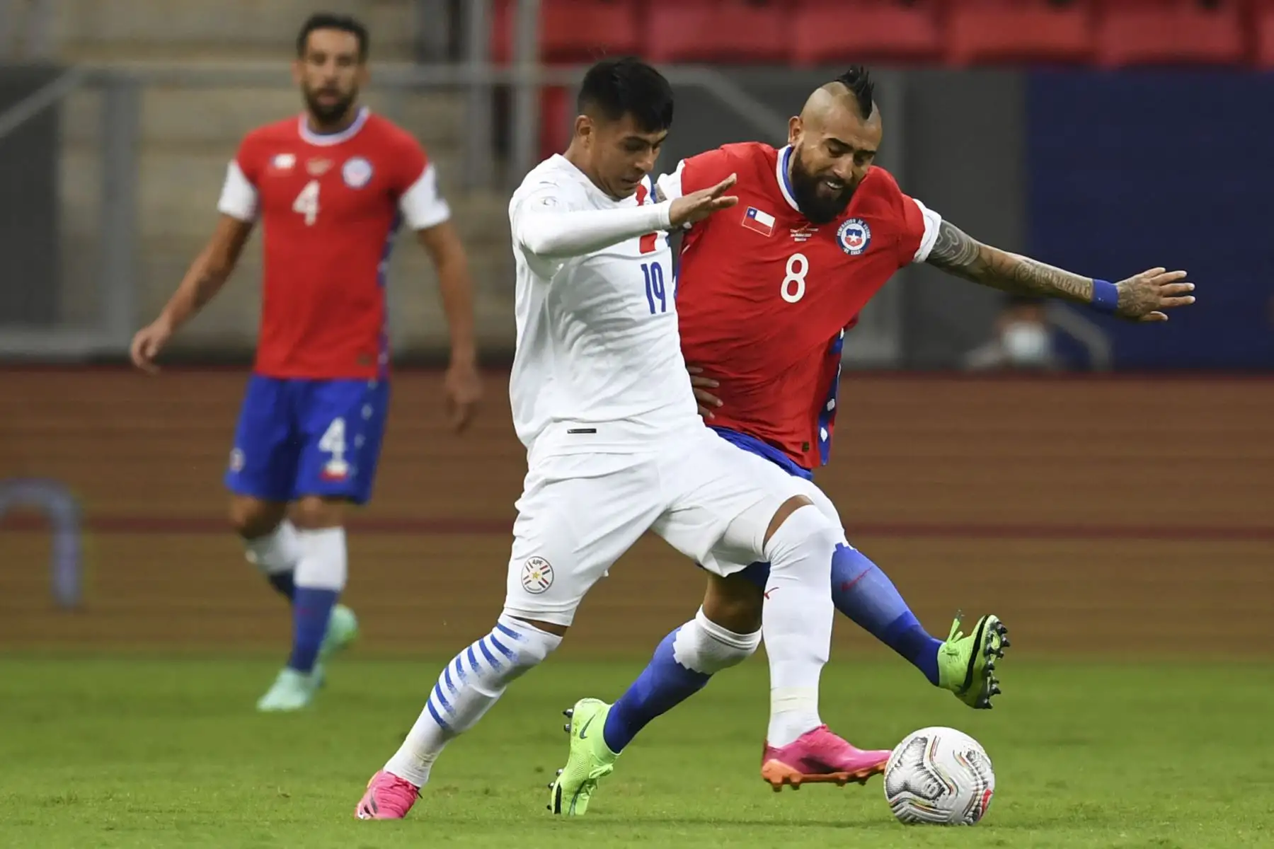 Santiago Arzamendia de Paraguay y Arturo Vidal de Chile compiten por el balón durante el partido de la fase de grupos de la Copa América, en el estadio Mane Garrincha de Brasilia. Foto: AFP