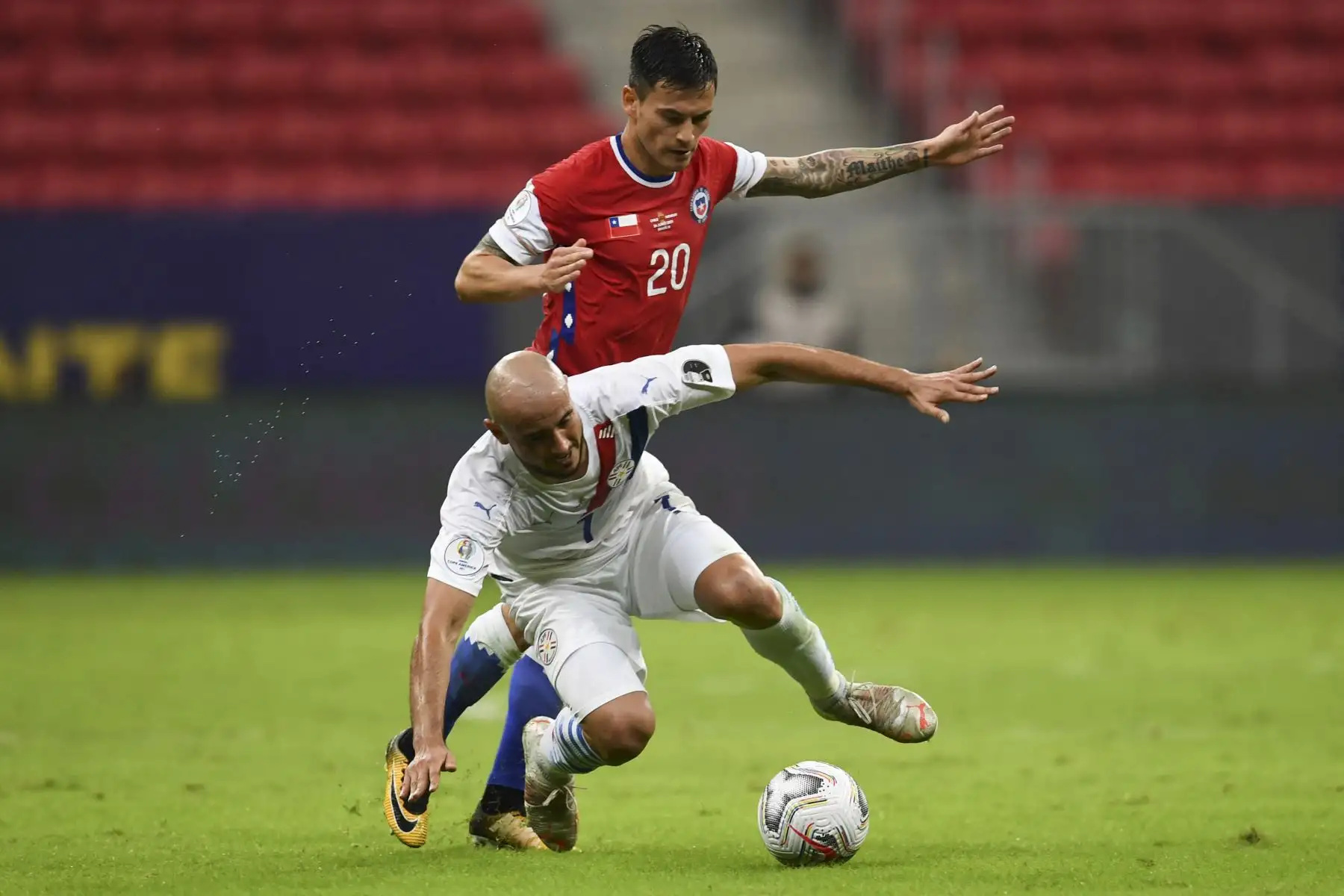 El chileno Charles Aranguiz y el paraguayo Carlos González compiten por el balón durante el partido de la fase de grupos de la Copa América 2021, en el Estadio Mane Garrincha de Brasilia. Foto: AFP