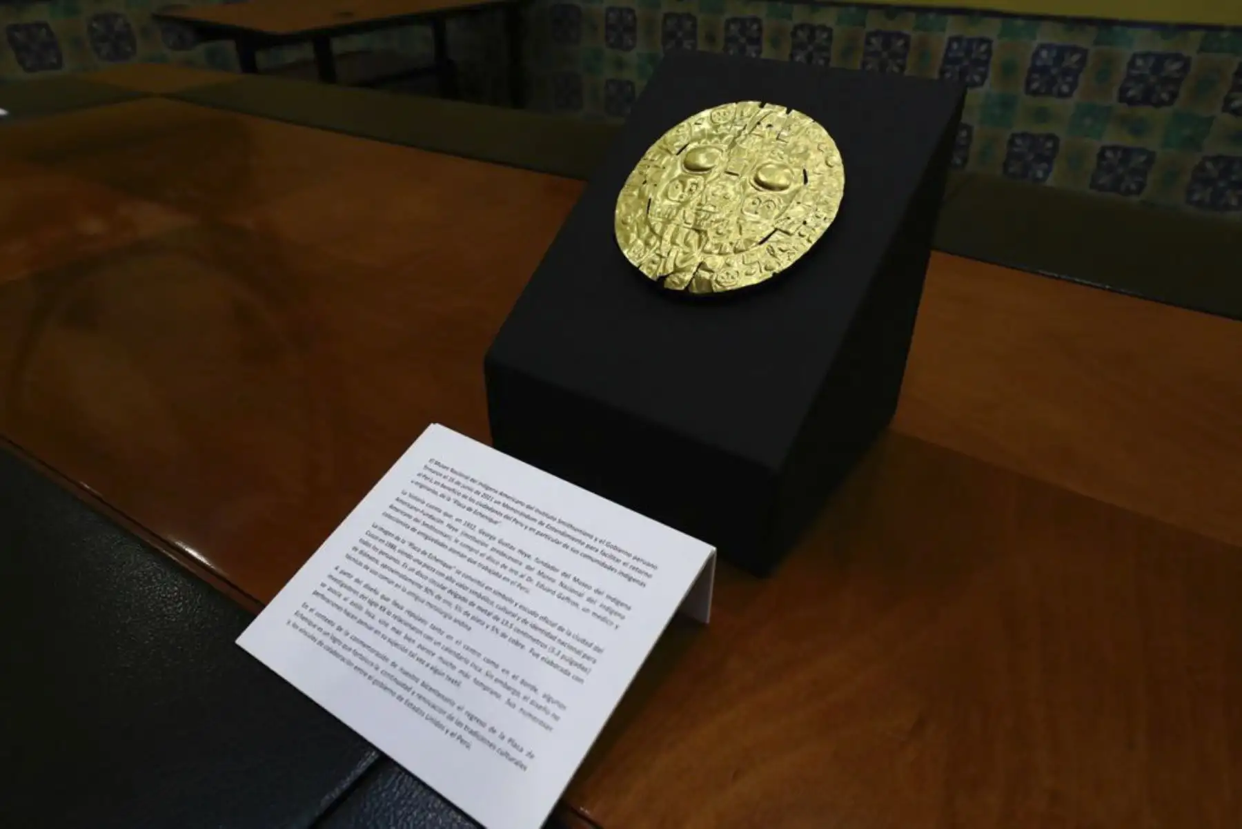 Es un disco circular, delgado, de metal, de 13.5 centímetros (5.3 pulgadas) de diámetro, aproximadamente 90% de oro, 5% de plata y 5% de cobre.  Fue elaborada con técnicas de uso común en la antigua metalurgia andina, y se considera que ha sido un adorno preinkaico para el pecho. Pertenece al estilo prehispánico Marcavalle o Chanapata, el cual se desarrolló durante el periodo Horizonte Temprano (900a.C.- 200a.C.). Foto: Ministerio de Cultura