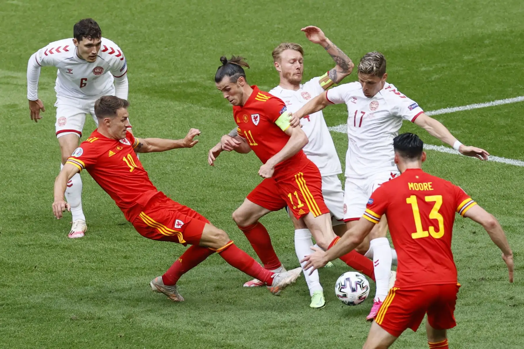 El delantero de Gales Gareth Bale  y el centrocampista de Gales Aaron Ramsey pelean por el balón con el defensor de Dinamarca Simon Kjaer (3R) y el defensor de Dinamarca Jens Stryger Larsen durante el partido de fútbol de octavos de final de la UEFA EURO 2020 entre Gales y Dinamarca.
Foto: AFP