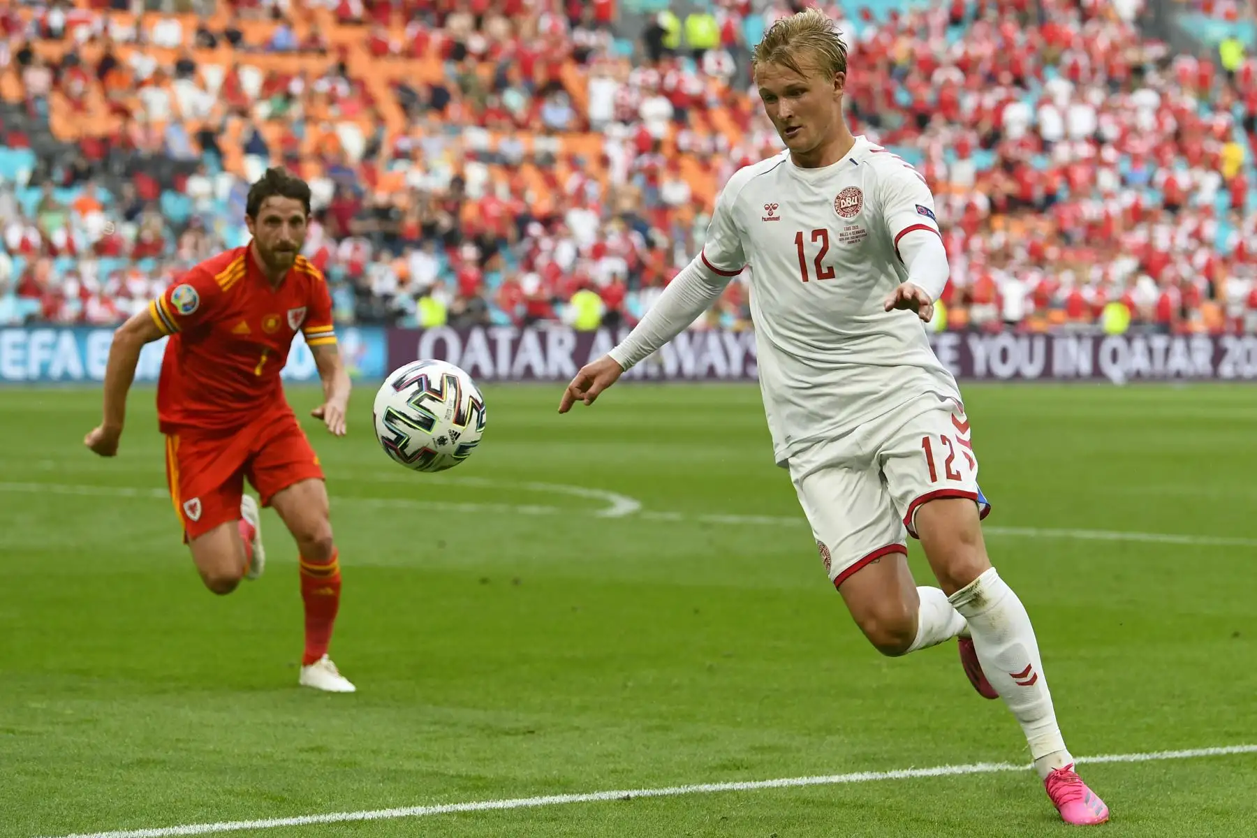 El delantero de Dinamarca Kasper Dolberg corre con el balón junto al mediocampista de Gales Joe Allen durante el partido de fútbol de octavos de final de la UEFA EURO 2020 entre Gales y Dinamarca en el Johan Cruyff Arena en Ámsterdam.
Foto: AFP