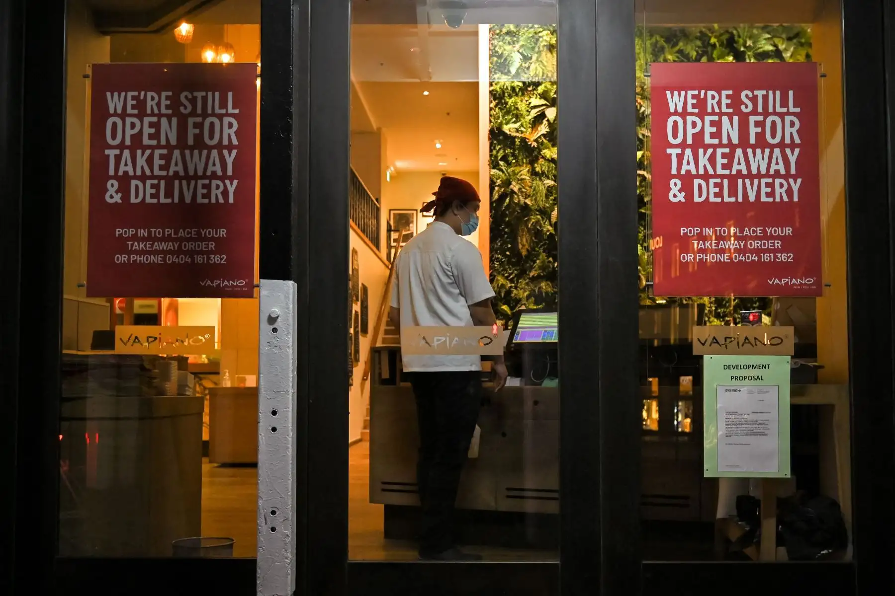 Un trabajador de un restaurante se encuentra en la entrada de un restaurante abierto para comida para llevar a lo largo de una calle tranquila en el centro de Sydney, en el primer día completo de un bloqueo de coronavirus de dos semanas para contener un brote de la variante Delta altamente contagiosa.
Foto: AFP