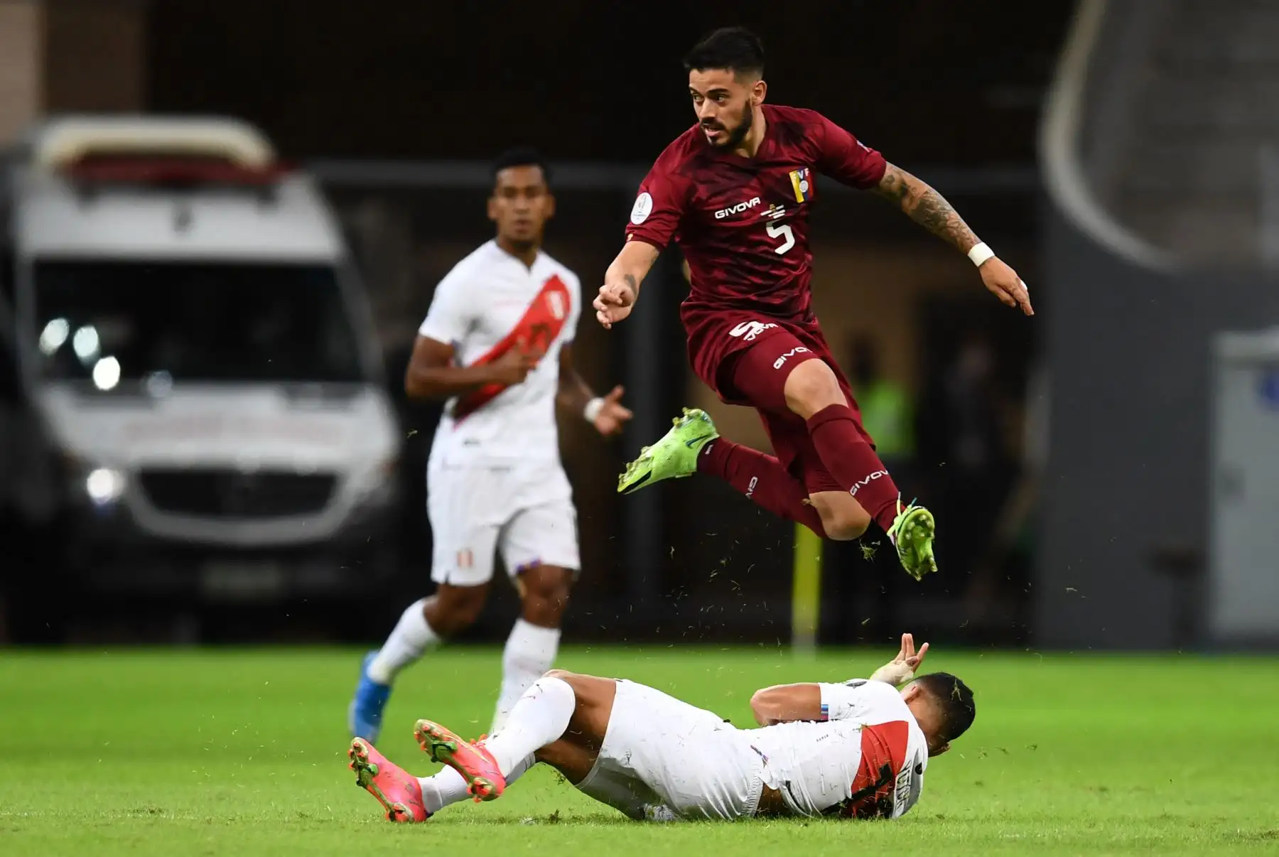 El venezolano Junior Moreno salta sobre el peruano Yoshimar Yotun durante el partido de la fase de grupos del torneo de fútbol Conmebol Copa América 2021 en el Estadio Mane Garrincha en Brasilia, Brasil. Foto: AFP