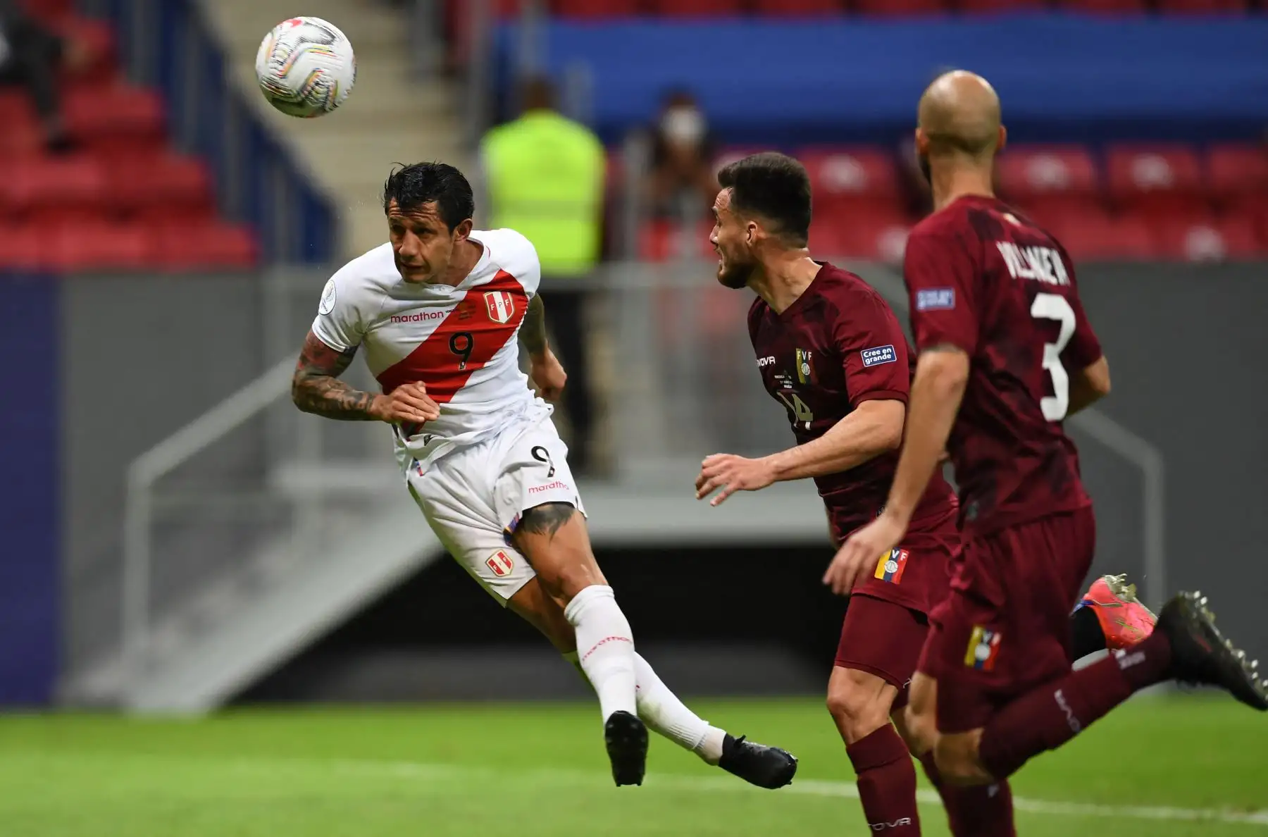 El peruano Gianluca Lapadula (L) y el venezolano Luis Del Pino Mago (C) compiten por el balón durante el partido de la fase de grupos del torneo de fútbol Conmebol Copa América 2021 en el Estadio Mane Garrincha en Brasilia, Brasil. Foto: AFP