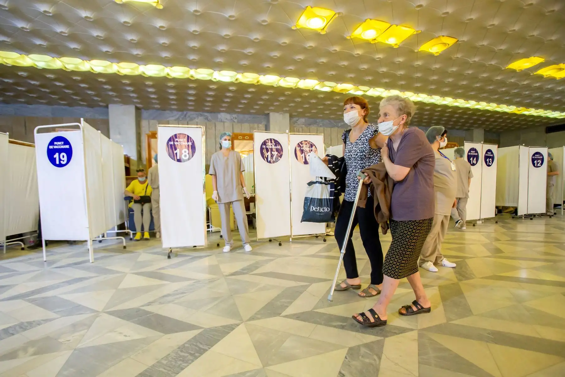 Dos mujeres abandonan el punto de vacunación tras recibir una inyección de dosis de la vacuna rusa Sputnik V, en la zona warderobe del Palacio Republicano de Chisinau , Moldavia, Rusia. Foto: EFE