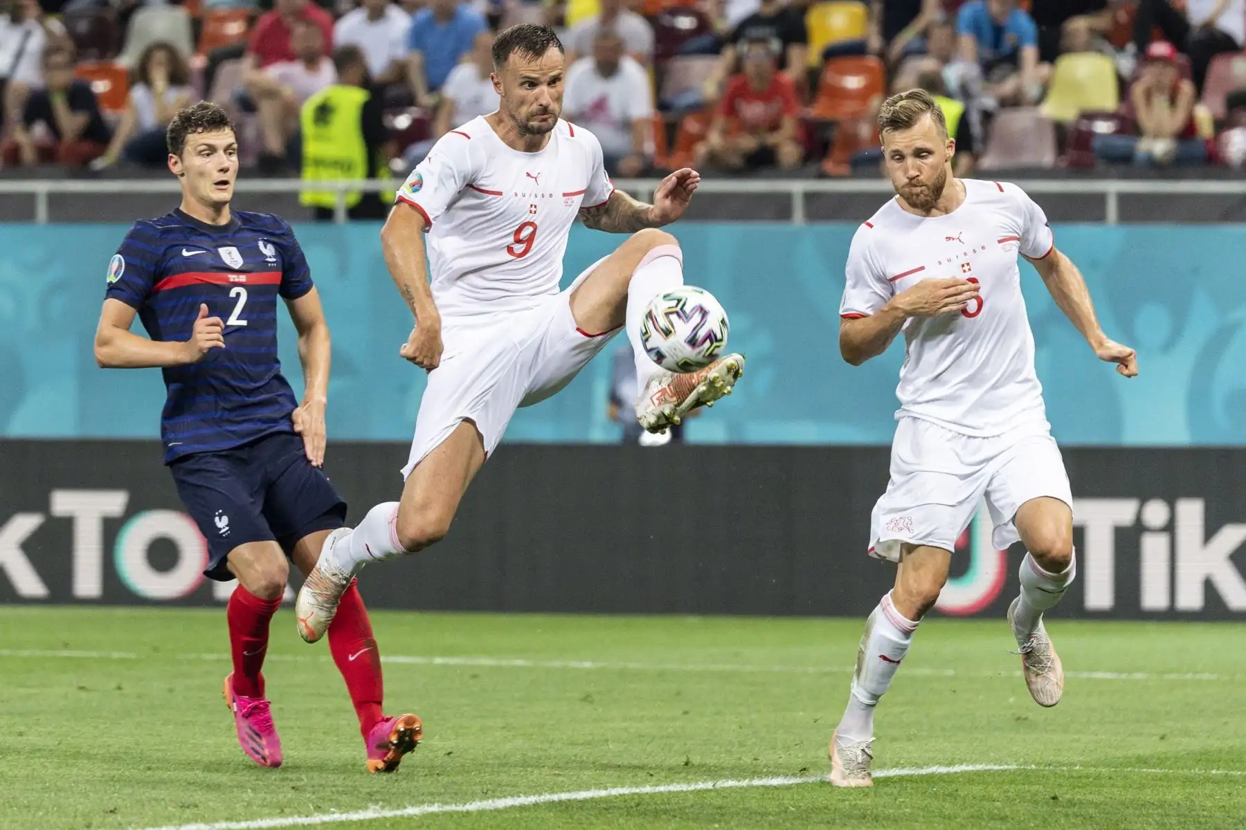 El francés Benjamin Pavard en acción contra los jugadores suizos Haris Seferovic y Silvan Widmer durante los octavos de final de la UEFA EURO 2020. Foto: EFE