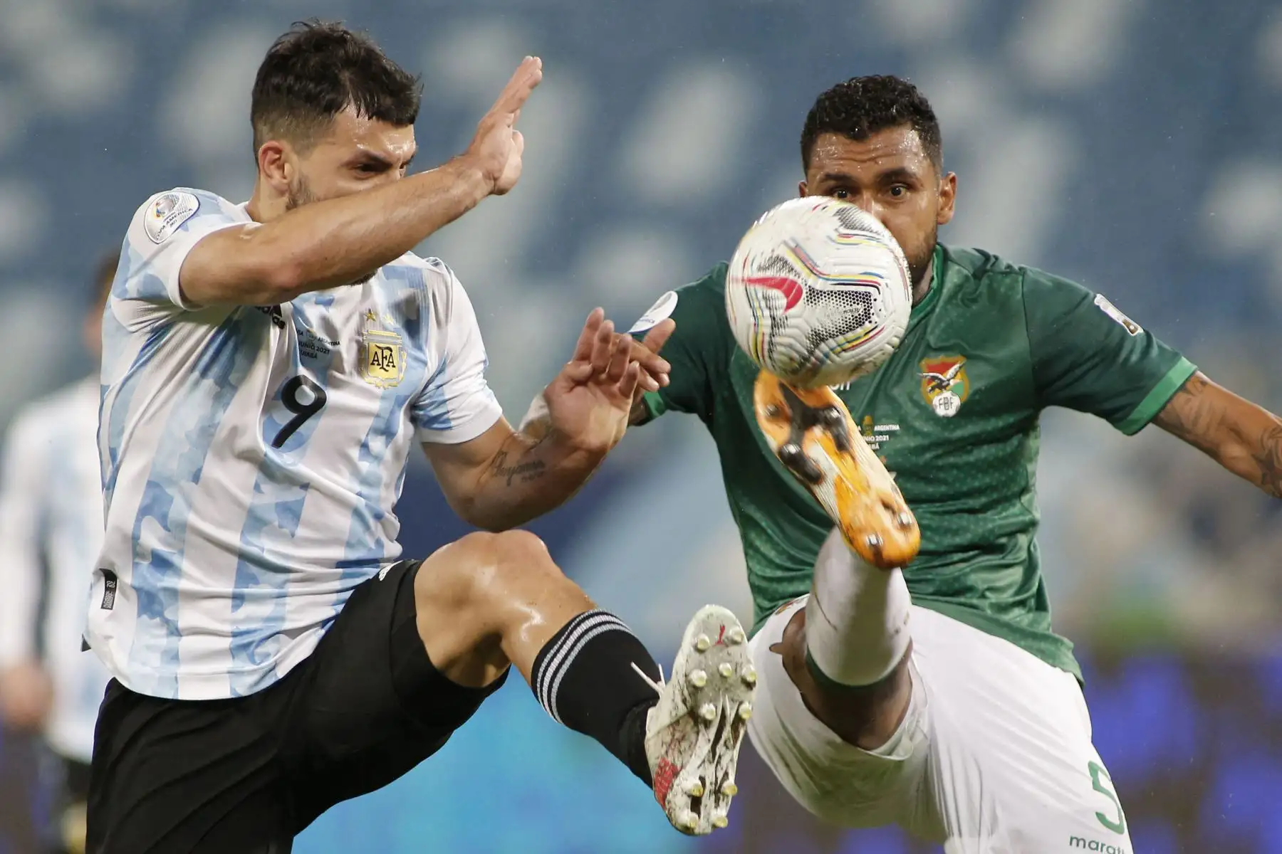 El argentino Sergio Agüero y el boliviano Adrián Jusino compiten por el balón durante el partido de la fase de grupos del torneo de fútbol Conmebol Copa América 2021 en el Estadio Arena Pantanal de Cuiabá, Brasil.
Foto: AFP