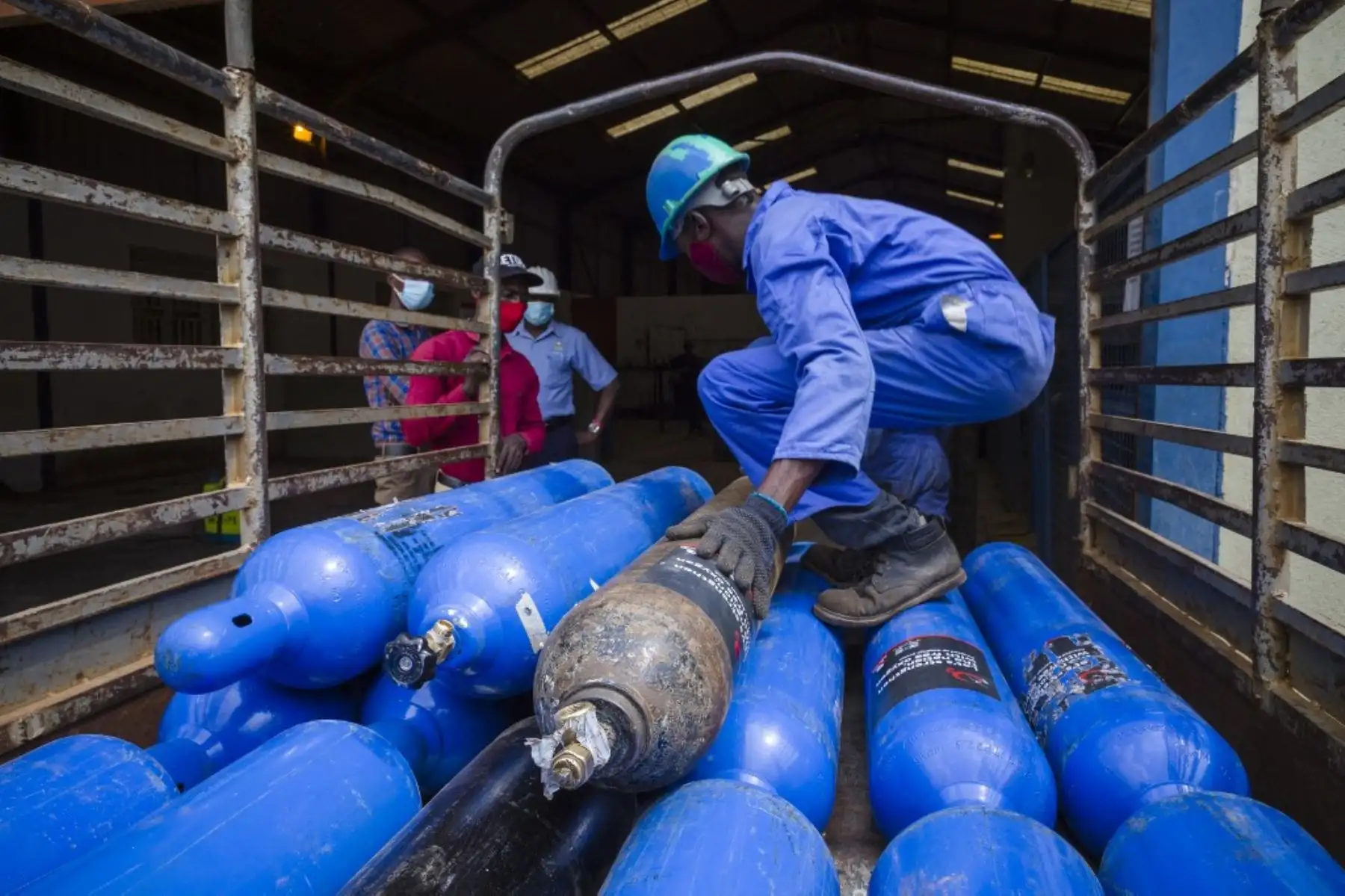 Los trabajadores de Roofing Rolling Mills cargan tanques de oxígeno en un vehículo para ser distribuidos a varios hospitales en Uganda, sin cargo, en su fábrica en Namanve, Wakiso, Uganda. Foto: AFP