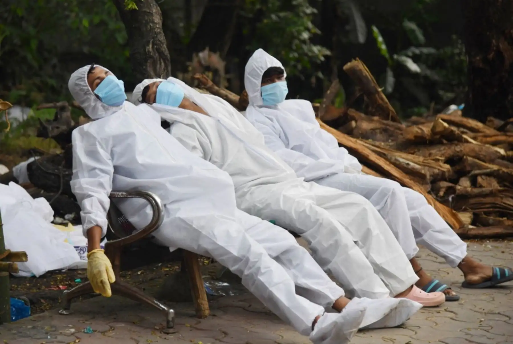 El personal de la ambulancia descansa en un banco después de su deber por el coronavirus covid-19 en un crematorio en Guwahati. Foto: AFP