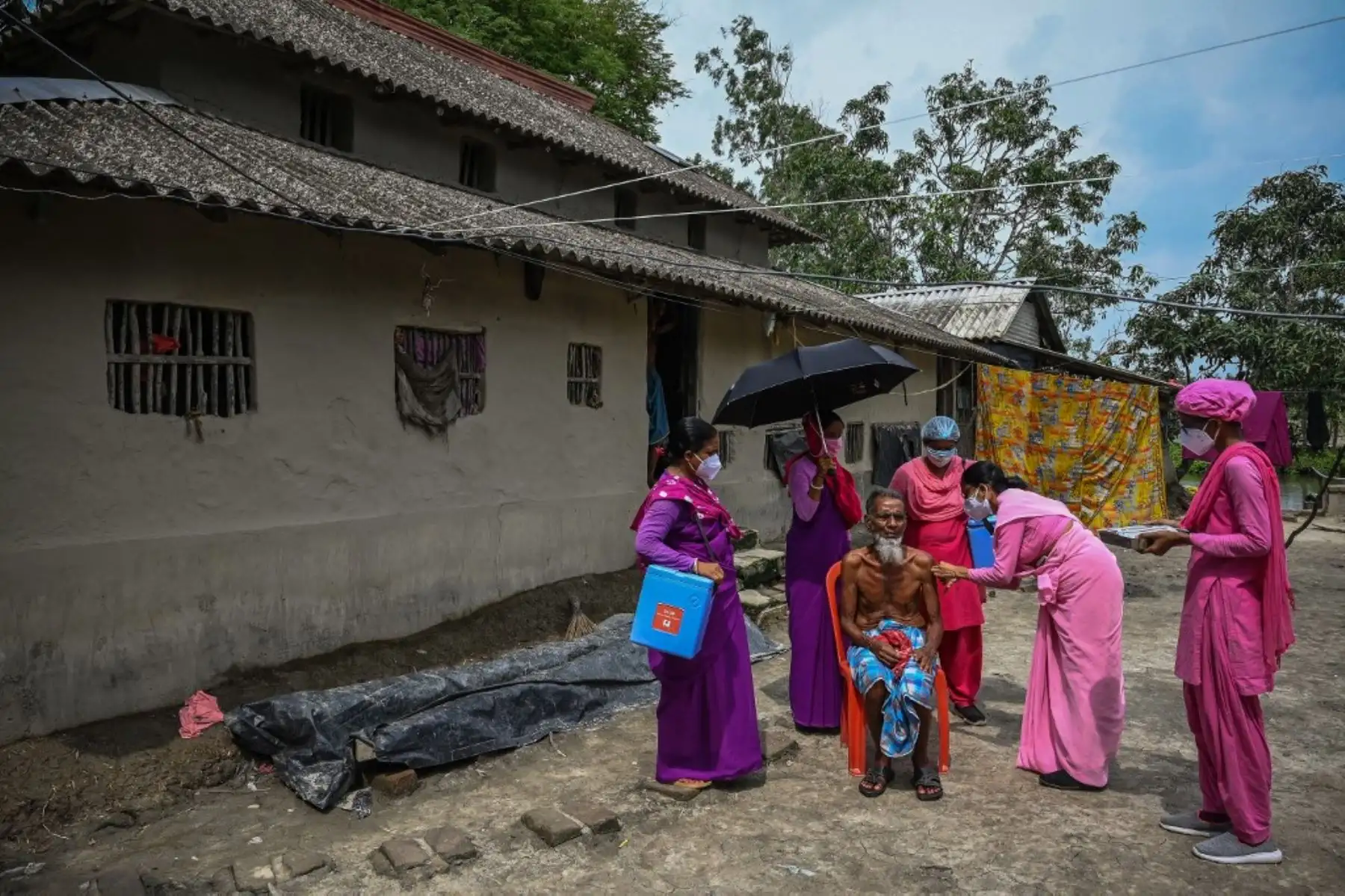 Los trabajadores de la salud inoculan a un anciano en su aldea con la vacuna Covishield contra el coronavirus Covid-19, ya que no pudo llegar al centro de vacunación en el área de Sundarbans en el distrito sur de 24Parganas, a unos 100 kilómetros al sur de Calcuta. Foto: AFP