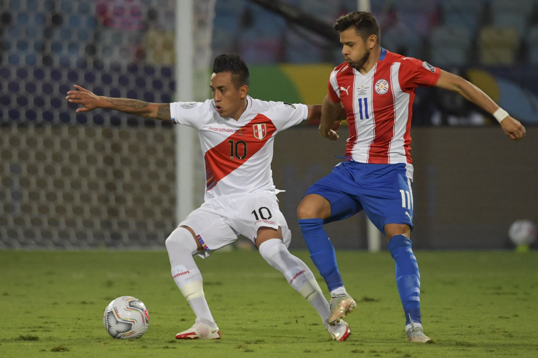 El peruano Christian Cueva y el paraguayo Angel Romero compiten por el balón durante el partido de cuartos de final de la Copa América 2021, en el Estadio Olímpico de Goiania, Brasil. Foto: AFP