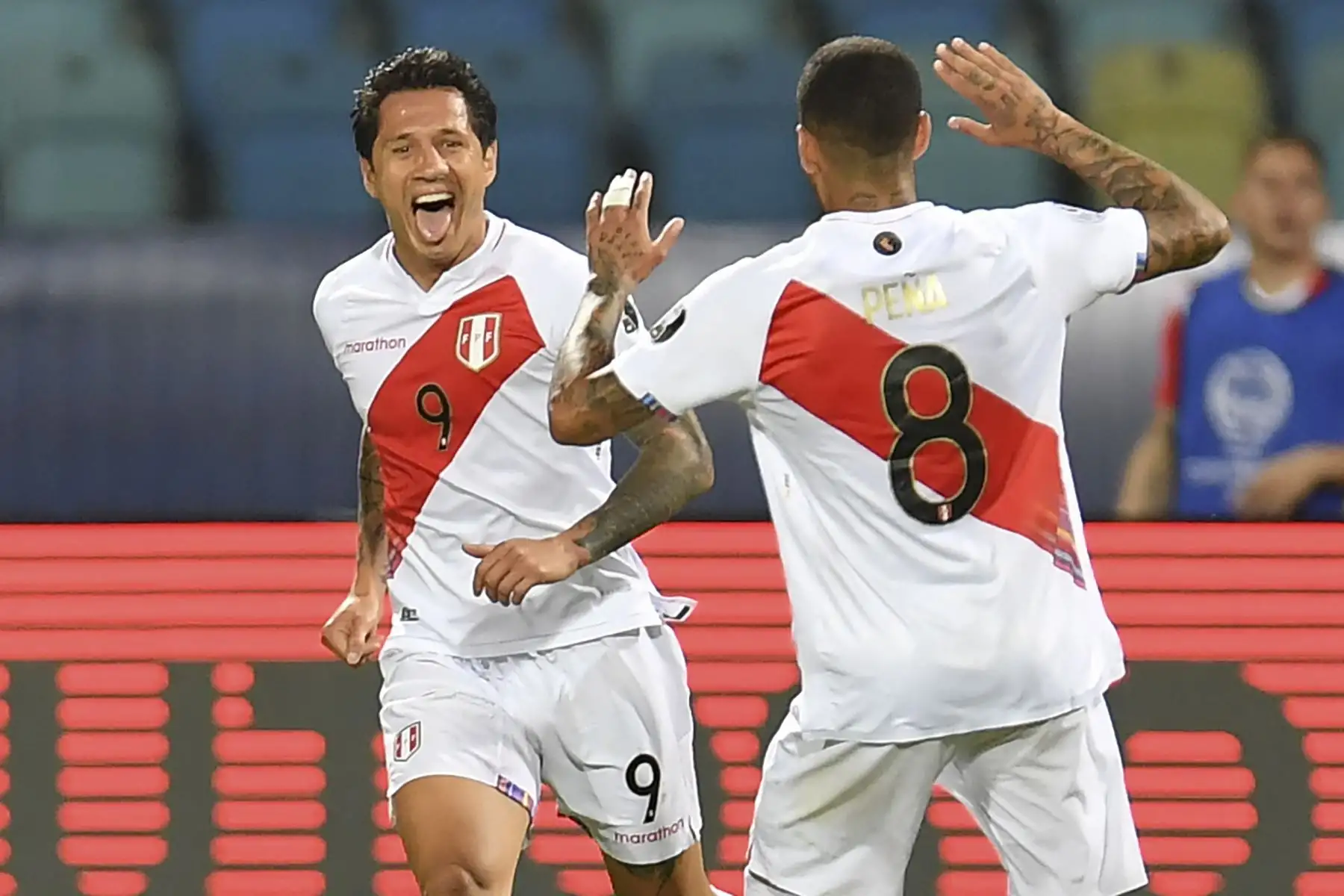 Gianluca Lapadula celebra con su compañero Sergio Peña después de anotar su segundo gol contra Paraguay durante el partido por cuartos de final de la Copa América 2021, en el Estadio Olímpico de Goiania, Brasil. Foto: AFP