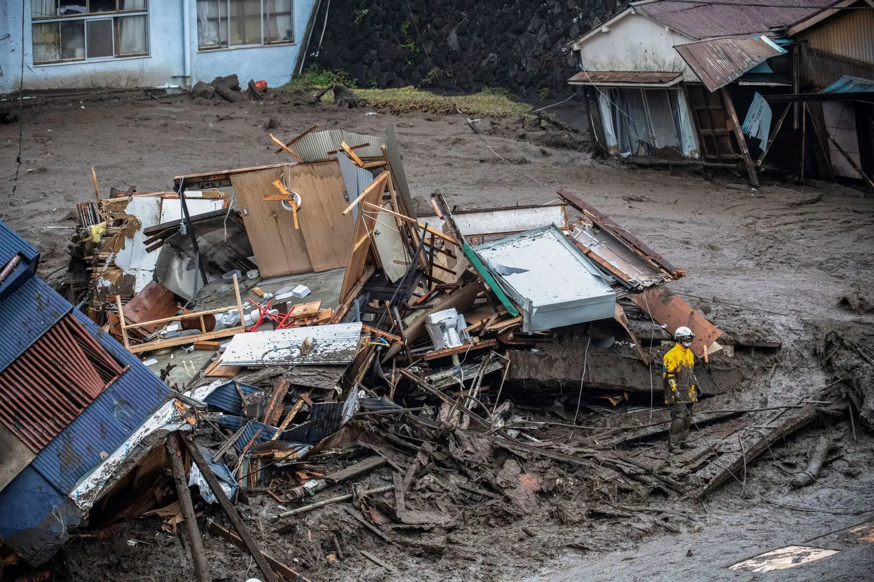 Un policía busca a personas desaparecidas en el lugar de un deslizamiento de tierra luego de días de fuertes lluvias en Atami, en la prefectura de Shizuoka.
Foto: AFP