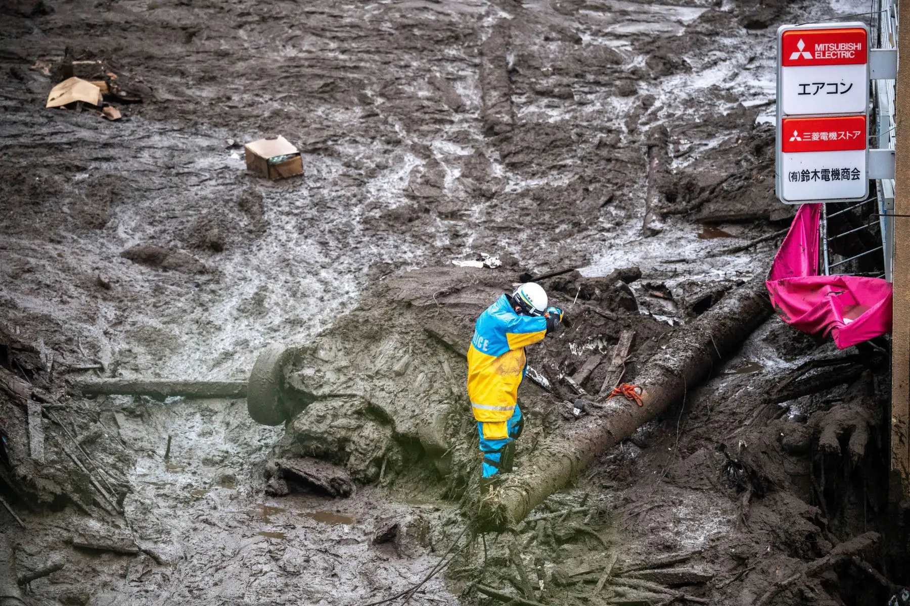 Un policía busca a personas desaparecidas en el lugar de un deslizamiento de tierra luego de días de fuertes lluvias en Atami, en la prefectura de Shizuoka.
Foto: AFP