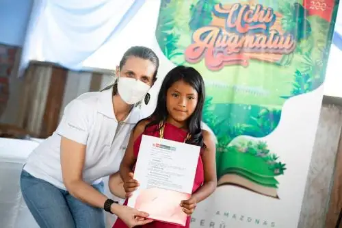 Presidenta ejecutiva de Indecopi, Hania Pérez de Cuéllar, entrega registro de derecho de autor a obra colectiva "Uchi Augmatui", cuentos escritos por menores Awajún. Foto: Cortesía.
