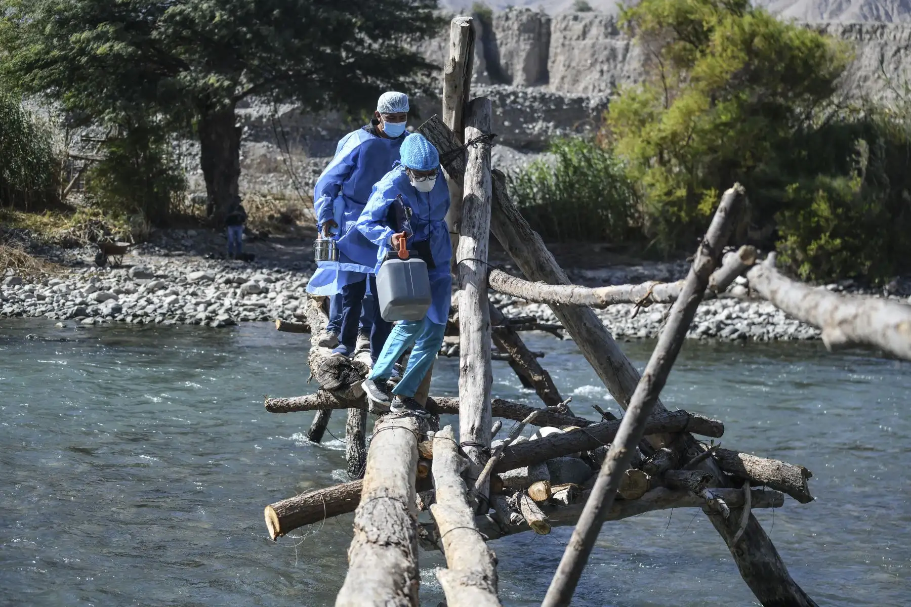 Trabajadores de salud cruzan el río Camaná para inocular a ancianos con dosis de la vacuna Pfizer-BioNTech contra COVID-19, en Arequipa, sur de Perú. Foto: AFP