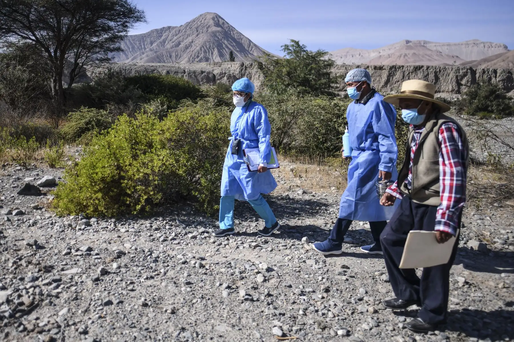 Trabajadores de salud cruzan el río Camaná para inocular a ancianos con dosis de la vacuna Pfizer-BioNTech contra COVID-19, en Arequipa, sur de Perú